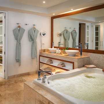 a bathroom with a large tub and a large mirror