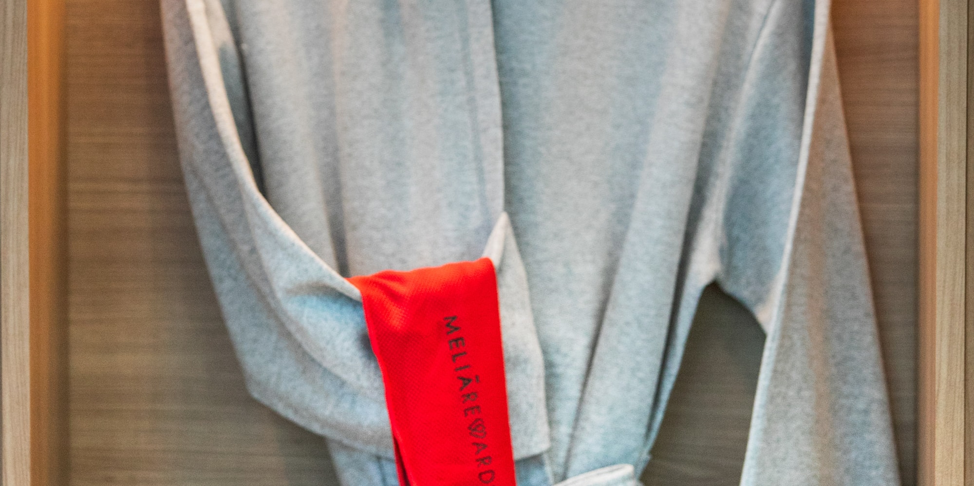 Grey bathrobe, playful cap, slippers, and INNSIDE by Meliá hotel amenities.