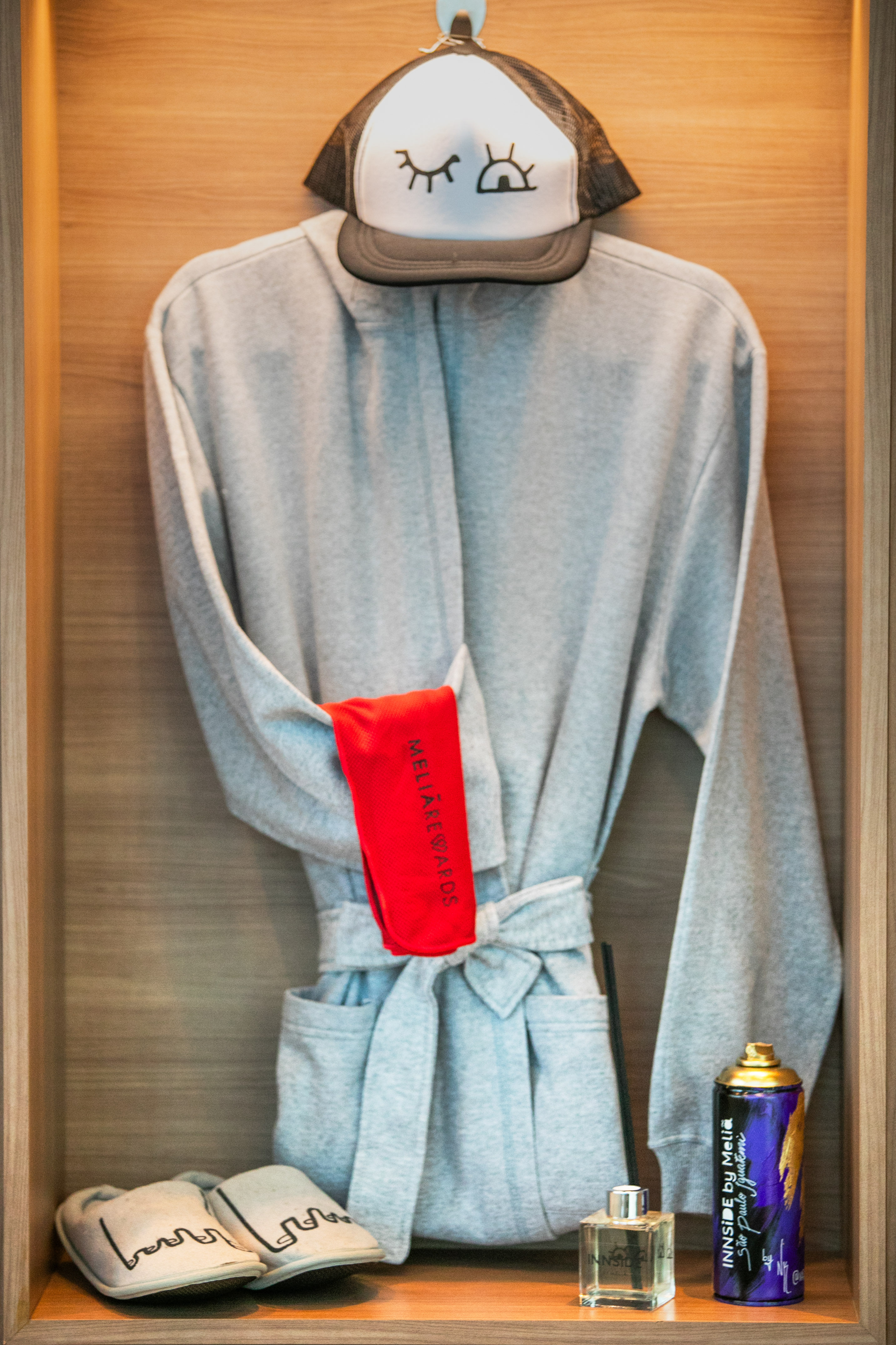 Grey bathrobe, playful cap, slippers, and INNSIDE by Meliá hotel amenities.