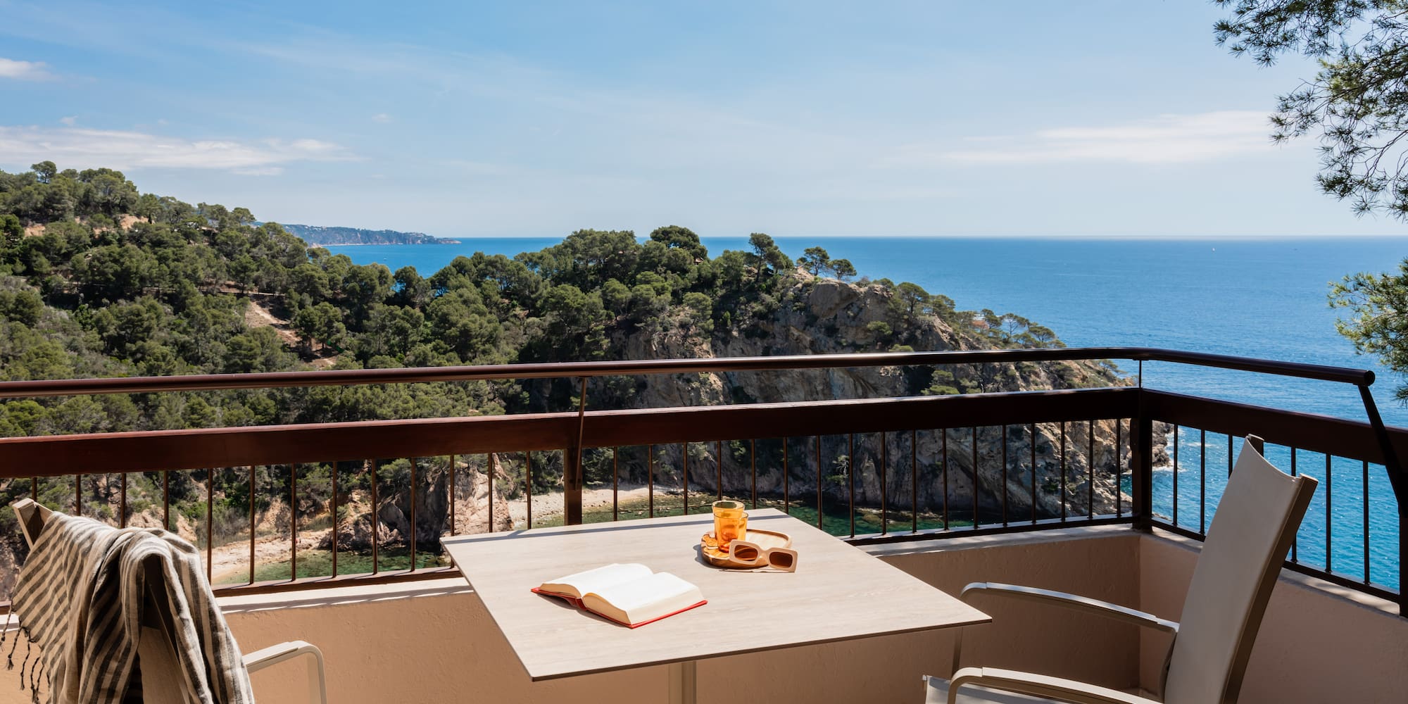 a table and chairs on a balcony overlooking a body of water