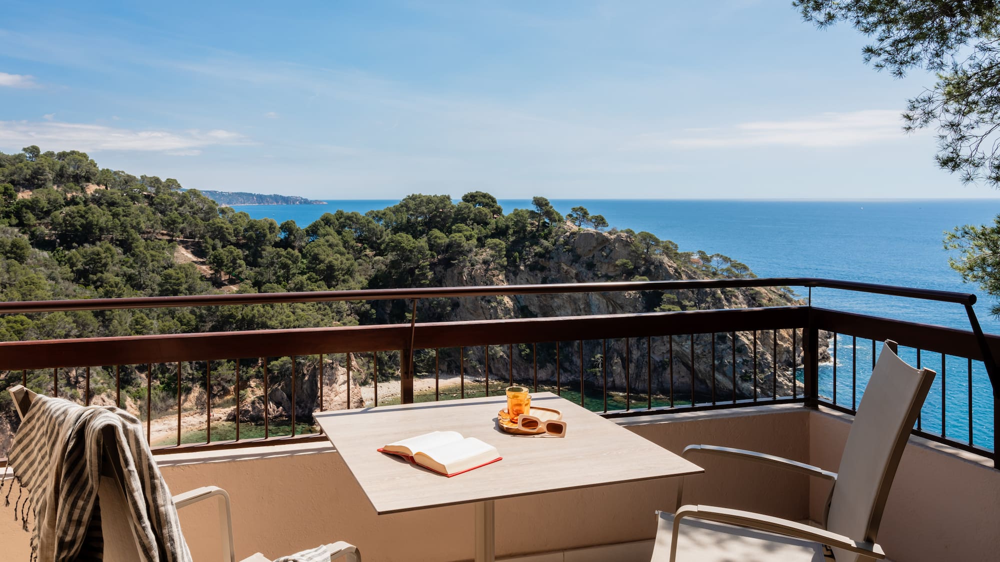 a table and chairs on a balcony overlooking a body of water