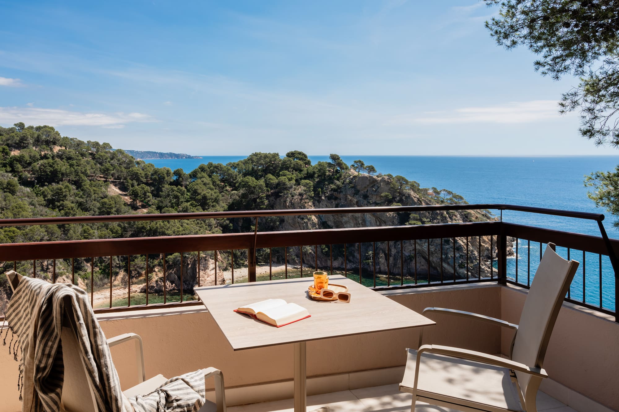 a table and chairs on a balcony overlooking a body of water