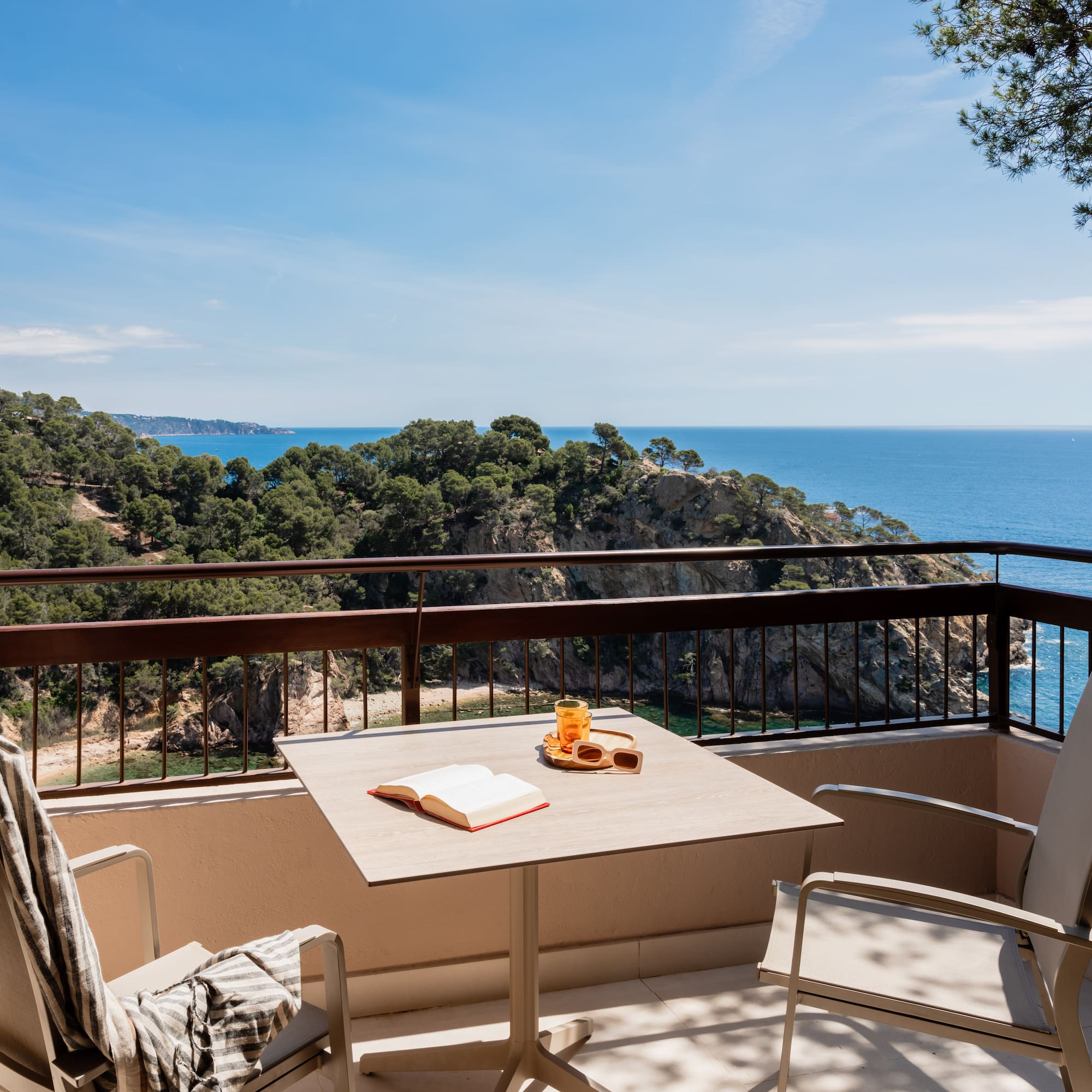 a table and chairs on a balcony overlooking a body of water