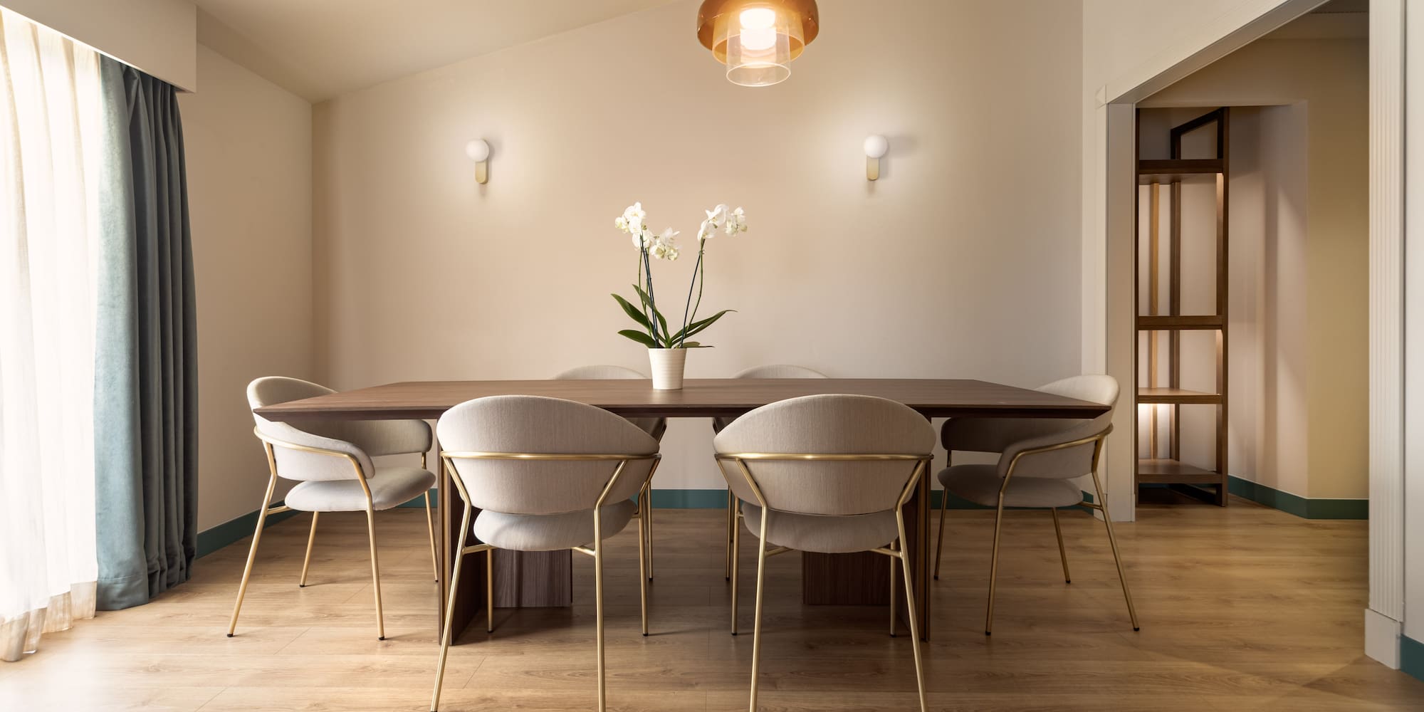 a dining table with chairs and a flower in it
