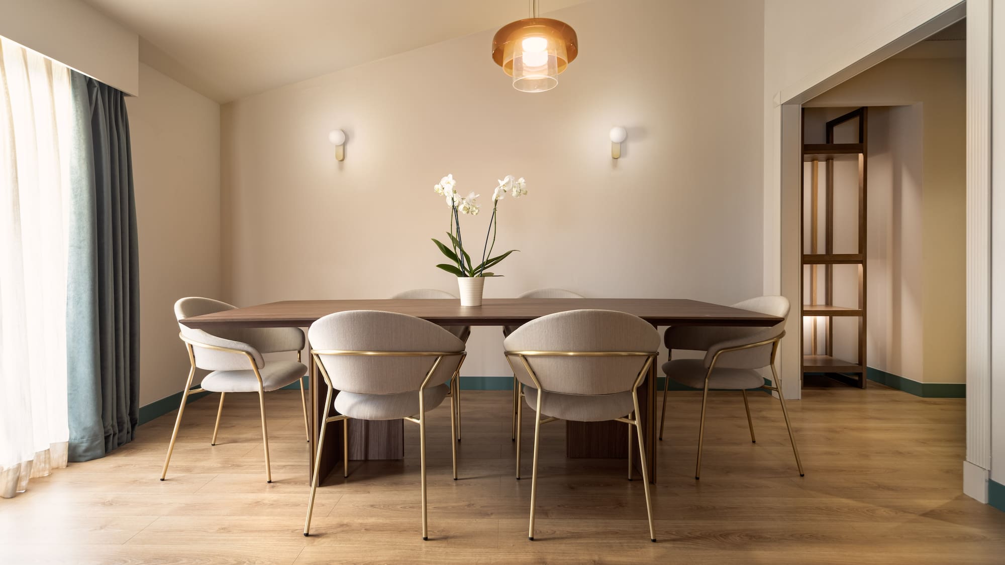a dining table with chairs and a flower in it