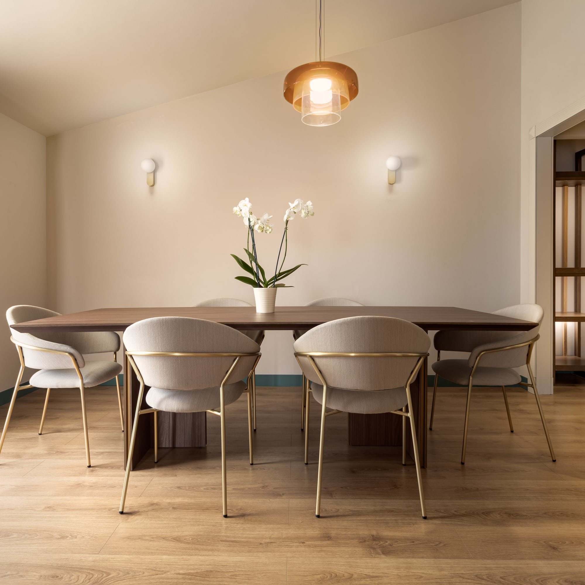 a dining table with chairs and a flower in it