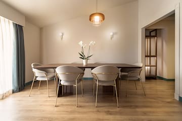 a dining table with chairs and a flower in it