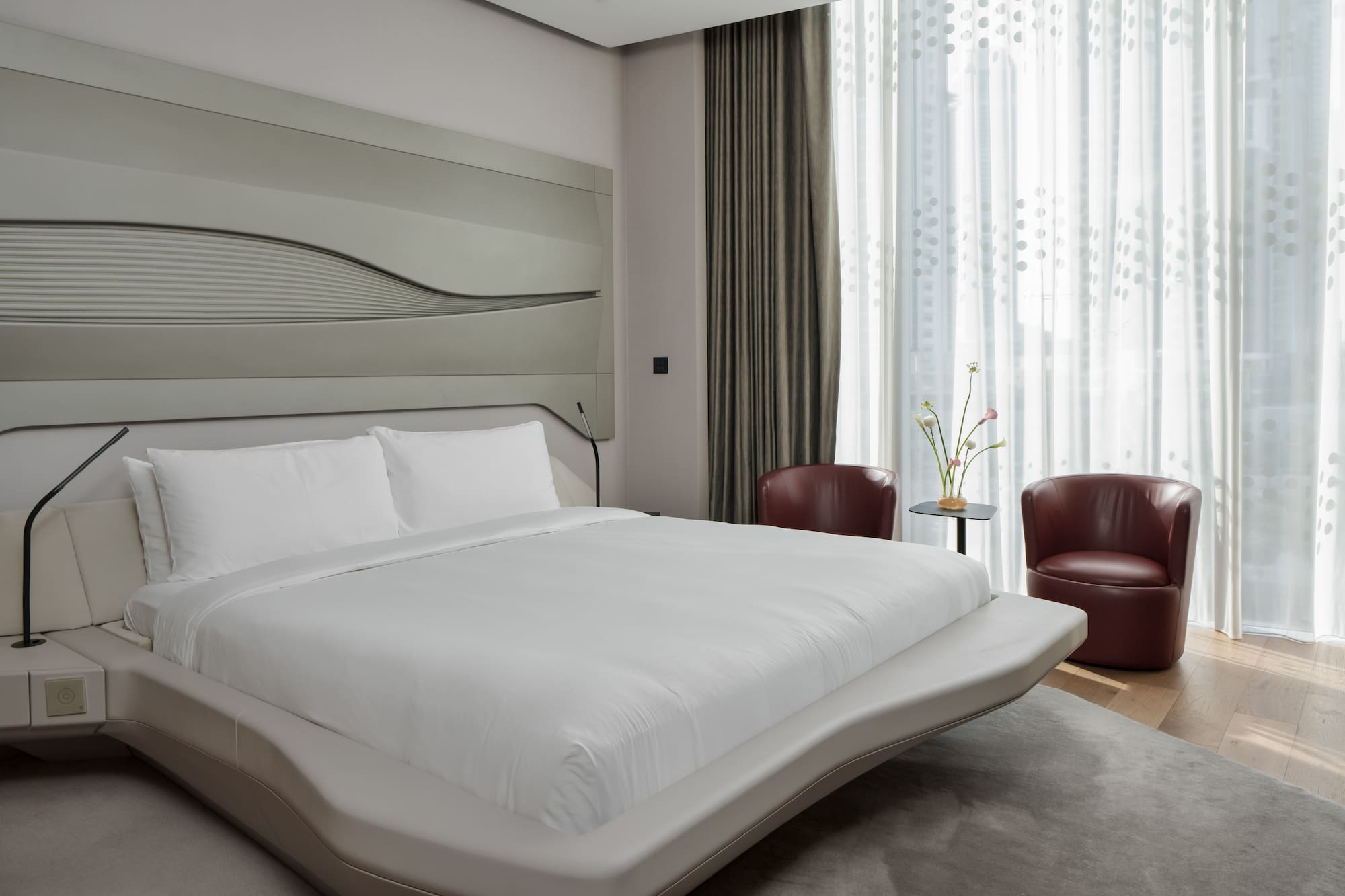 a bed with a headboard and chairs in a room