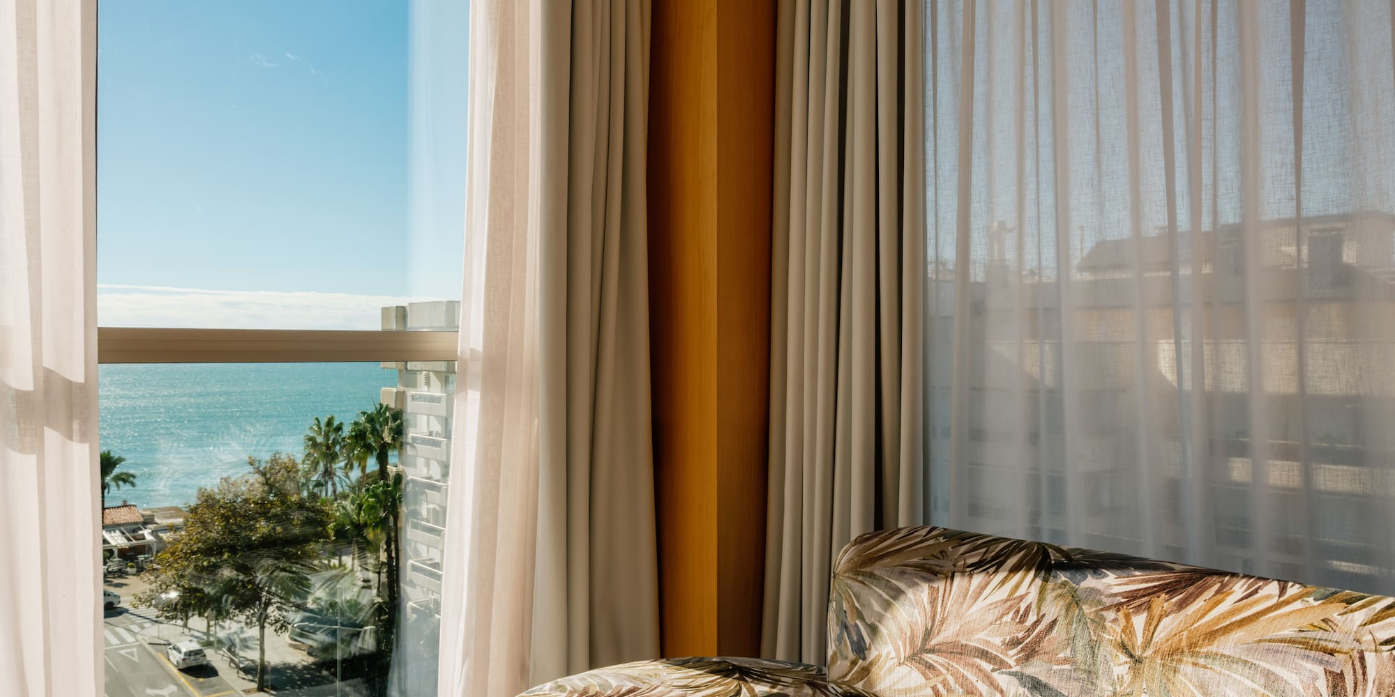 a couch in a room with a view of the ocean