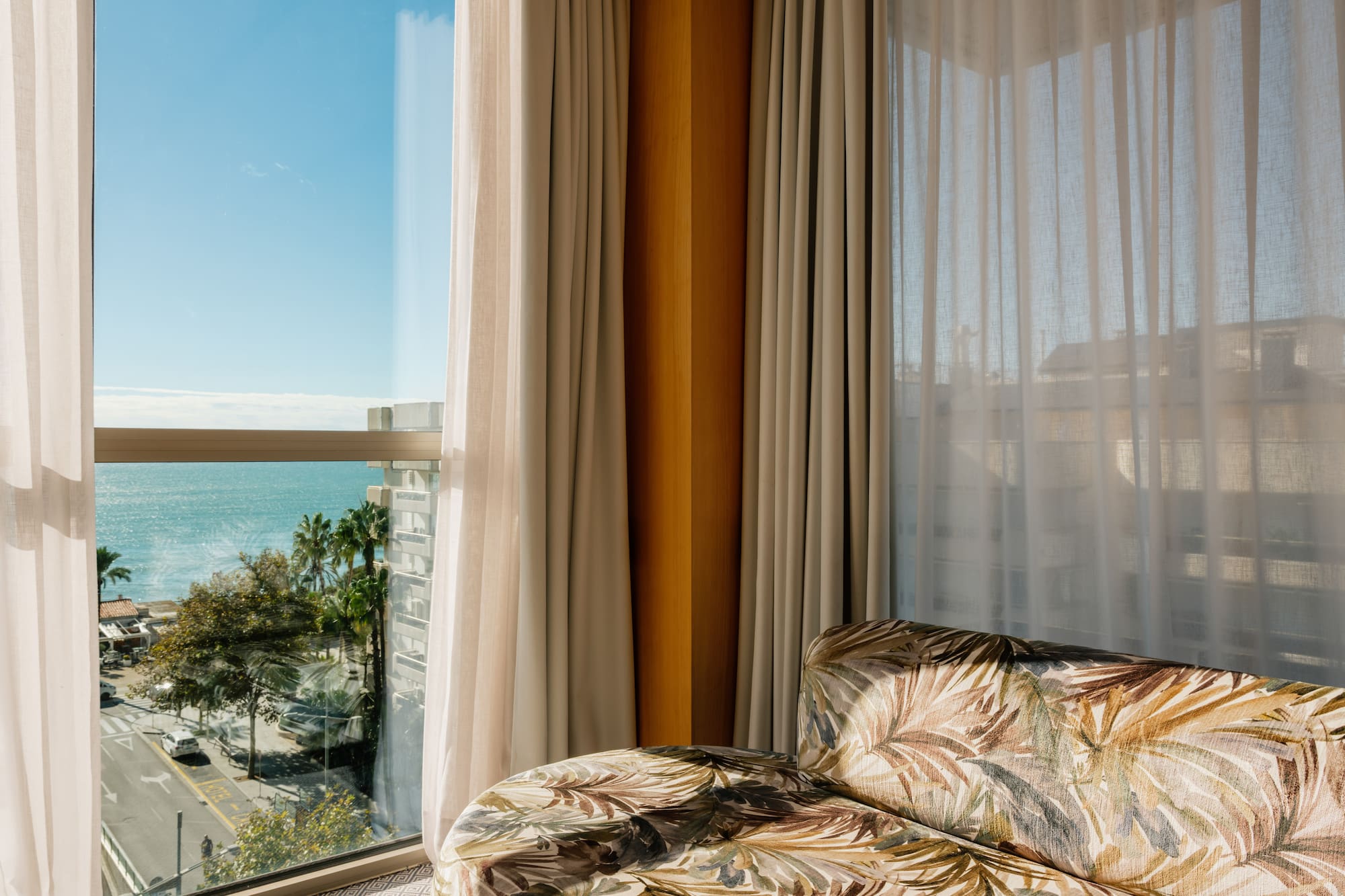 a couch in a room with a view of the ocean