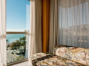 a couch in a room with a view of the ocean