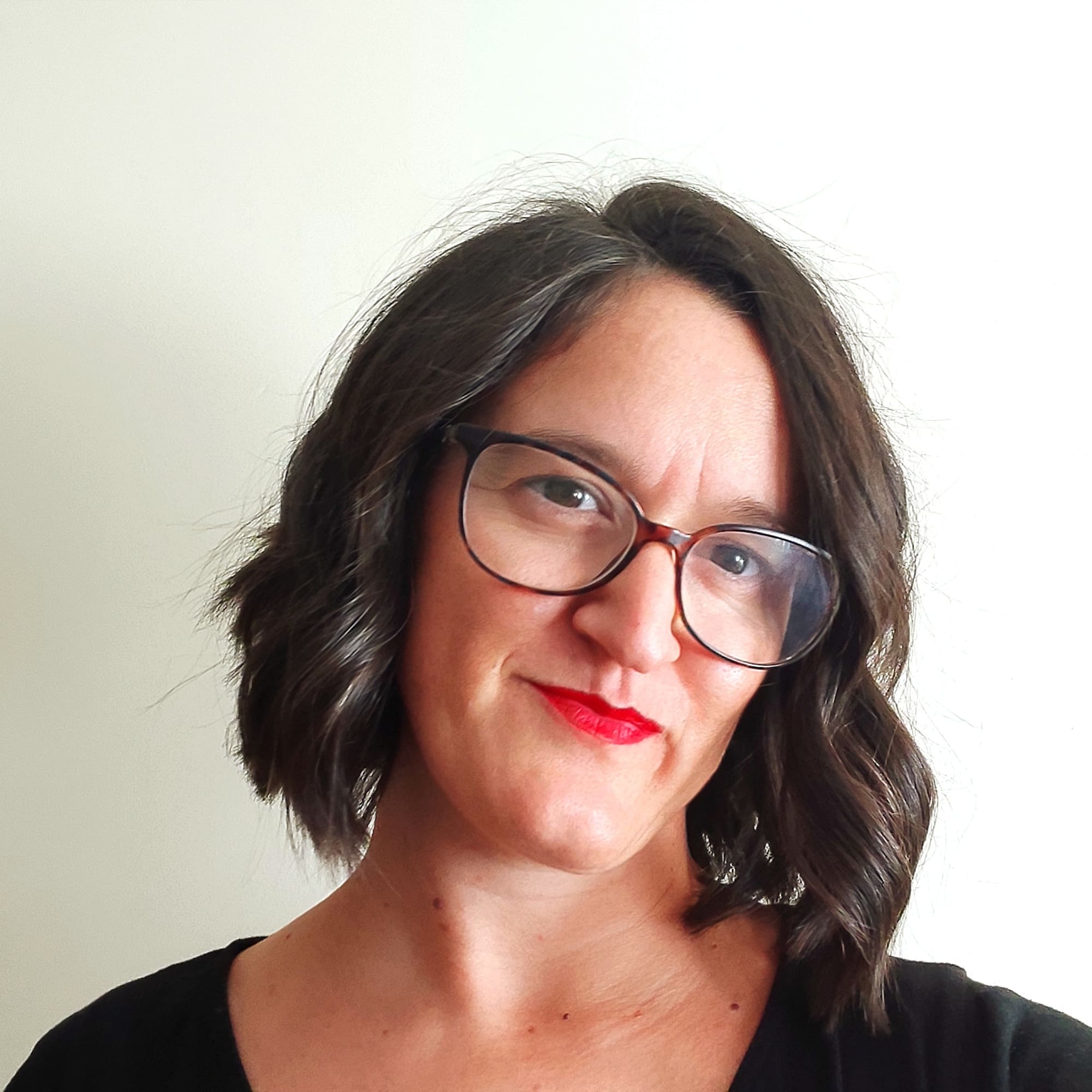 a woman with glasses smiling