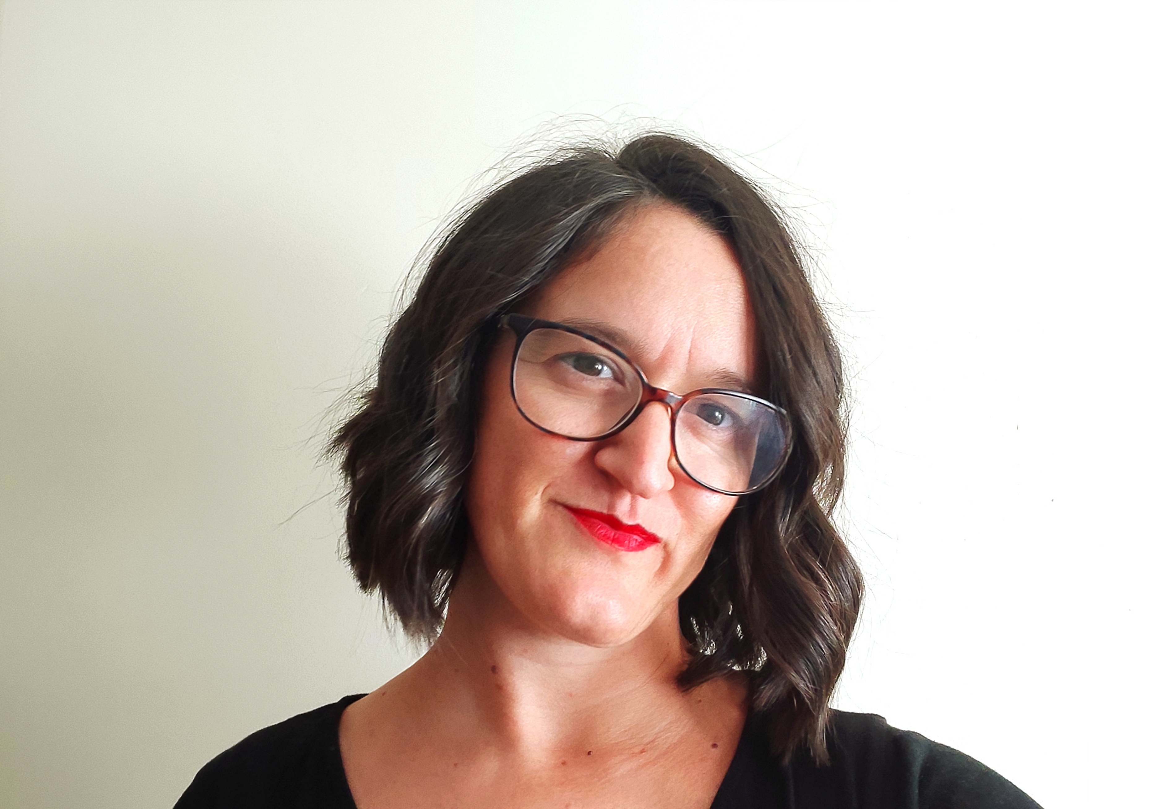 a woman with glasses smiling