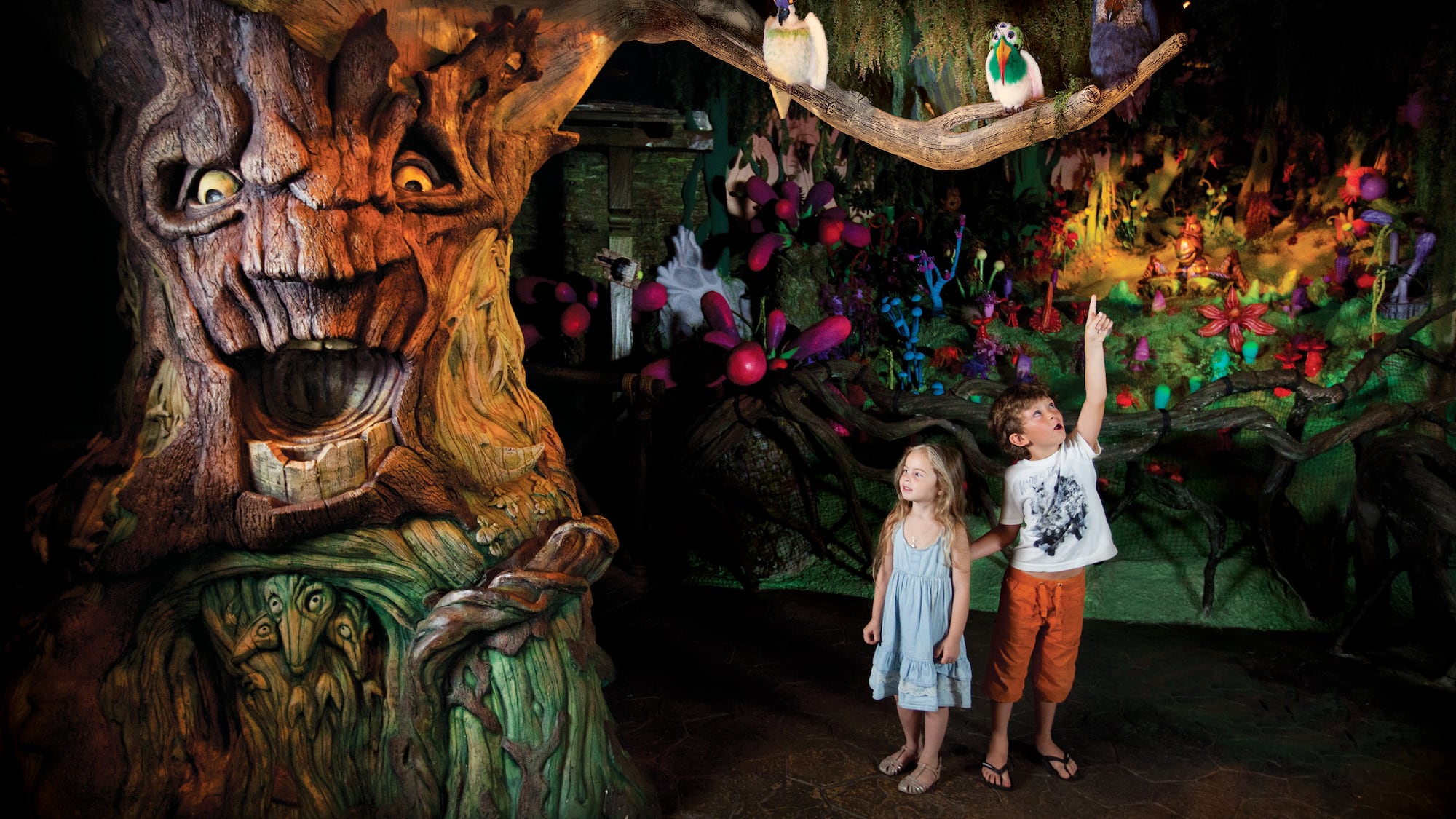 a children standing in front of a tree