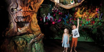 a children standing in front of a tree
