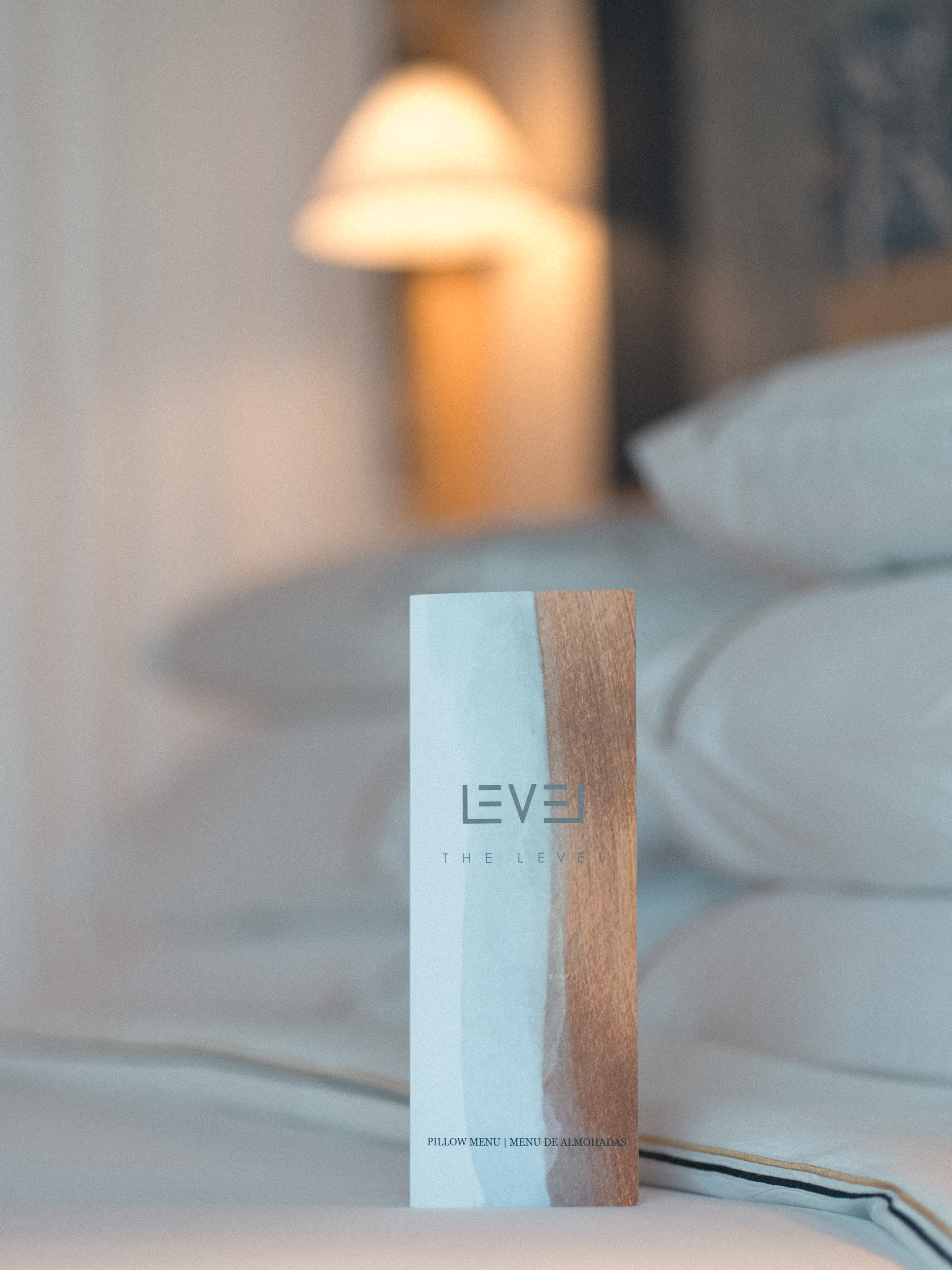 The Level pillow menu card on a luxury hotel bed.