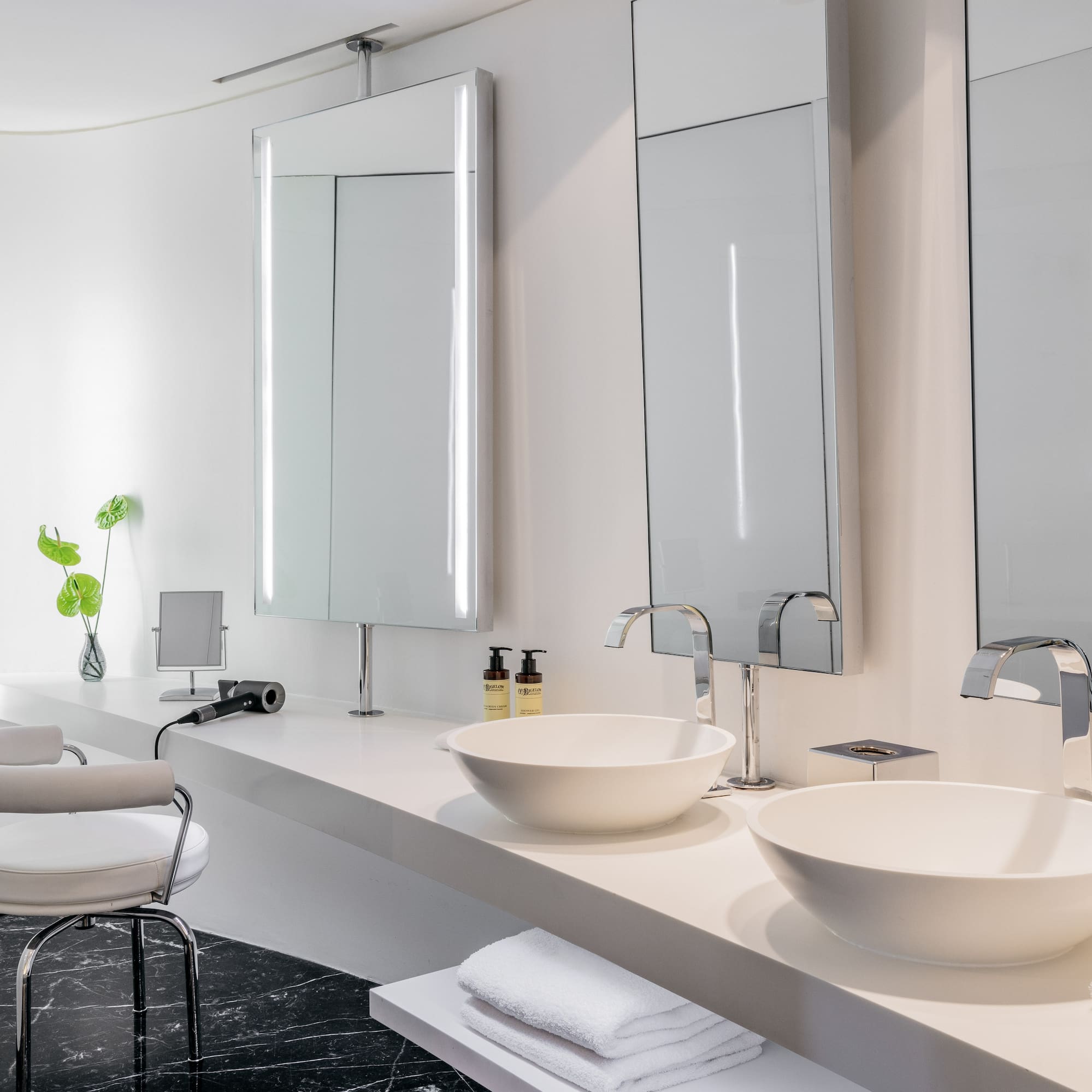 a bathroom with white sinks and mirrors