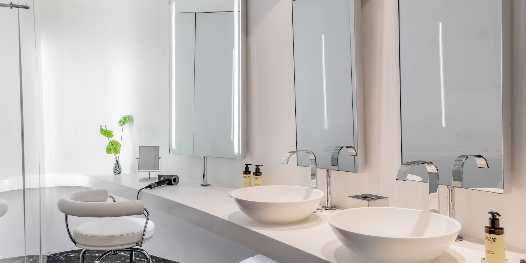 a bathroom with white sinks and mirrors
