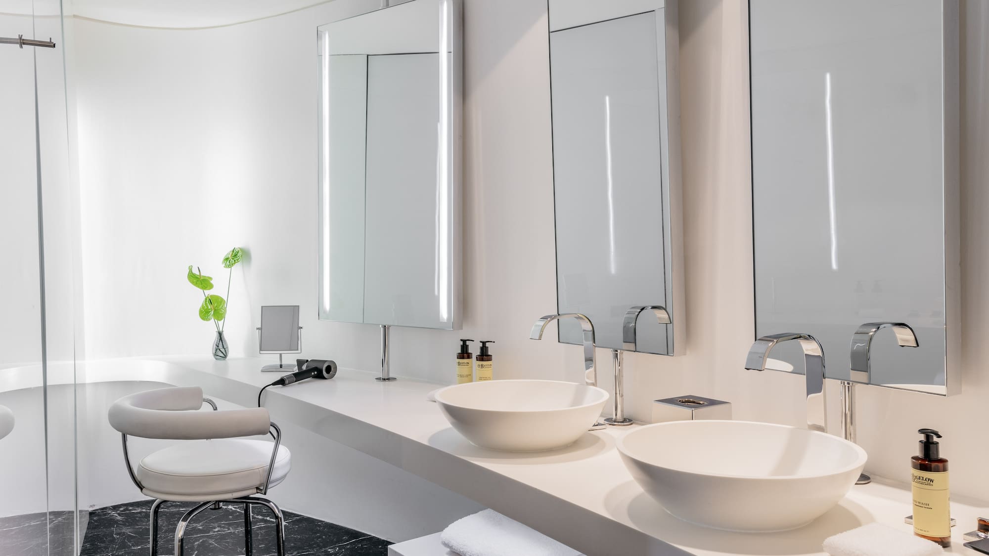 a bathroom with white sinks and mirrors
