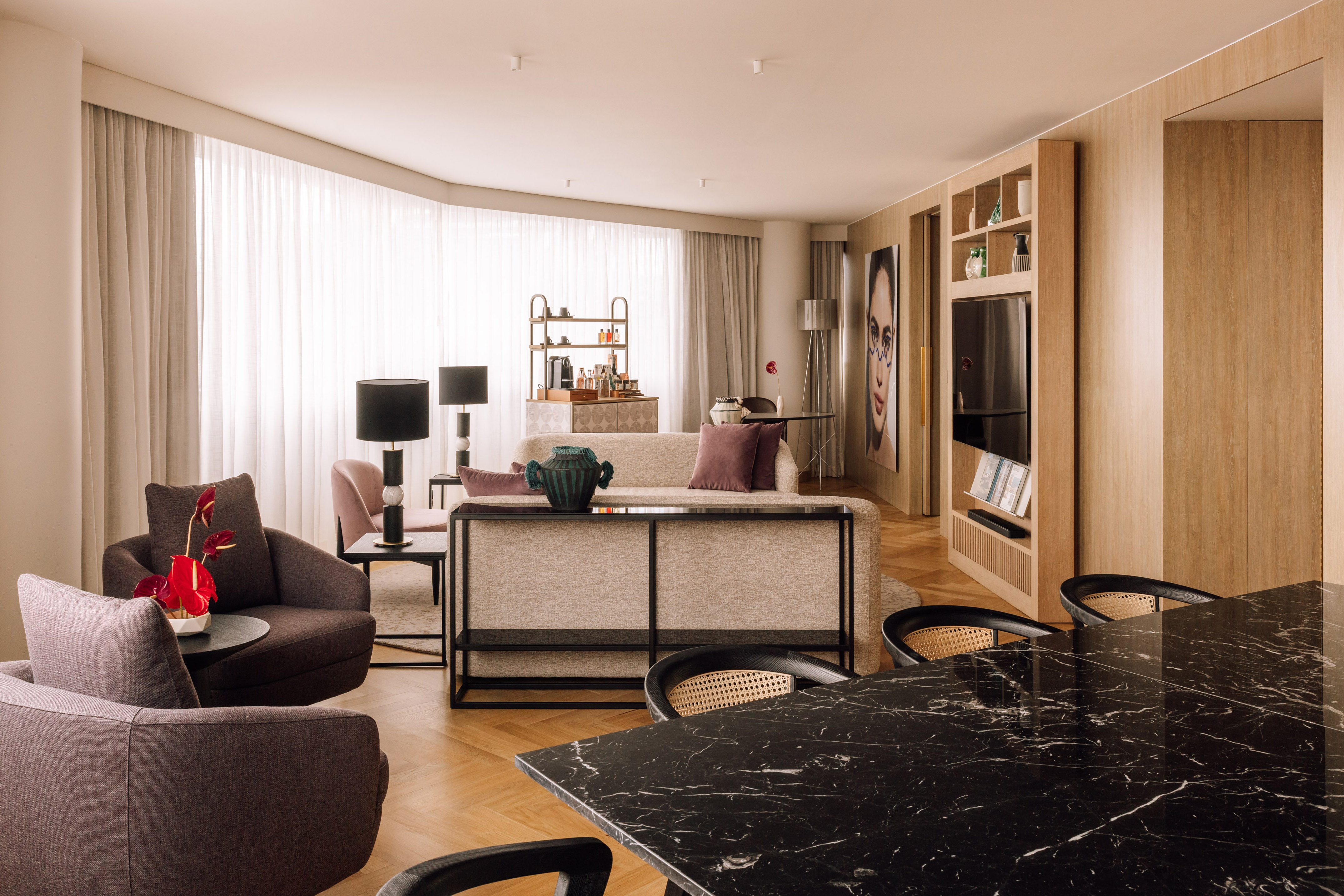 Modern living room with sofa, black marble table, and wood paneling.