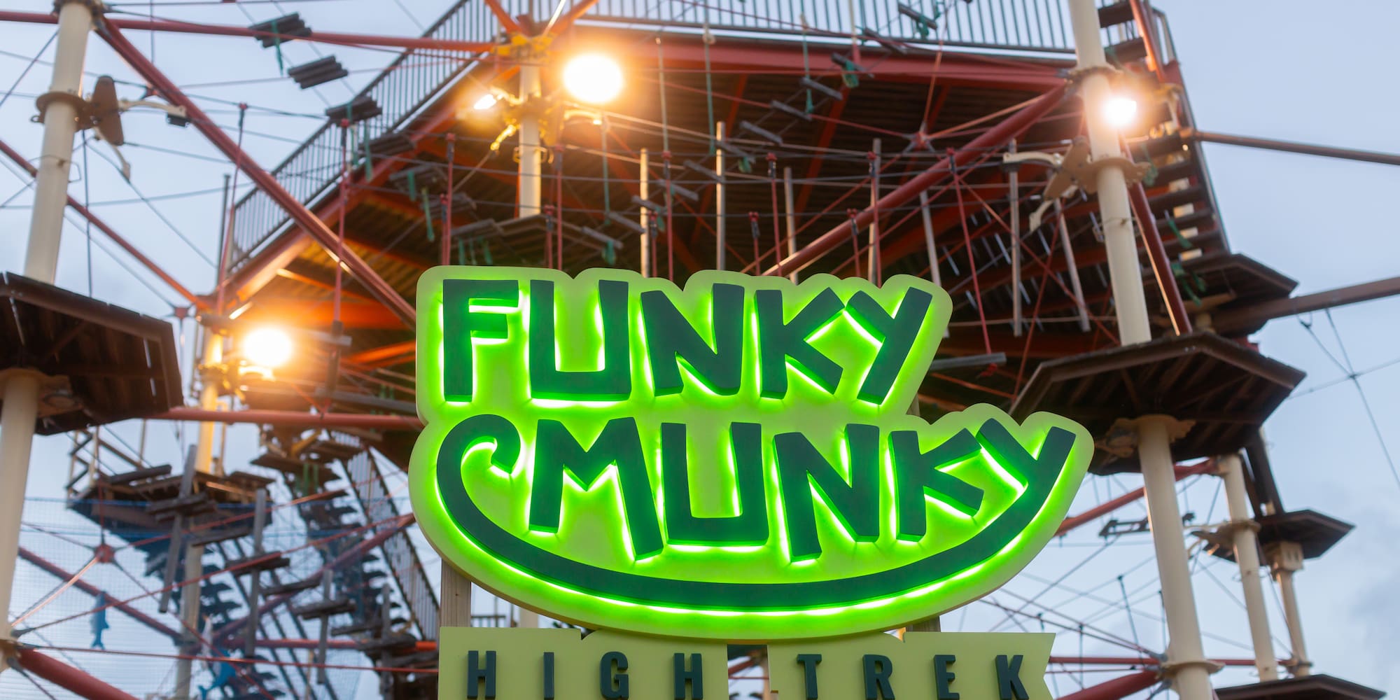 a sign with a ferris wheel in the background