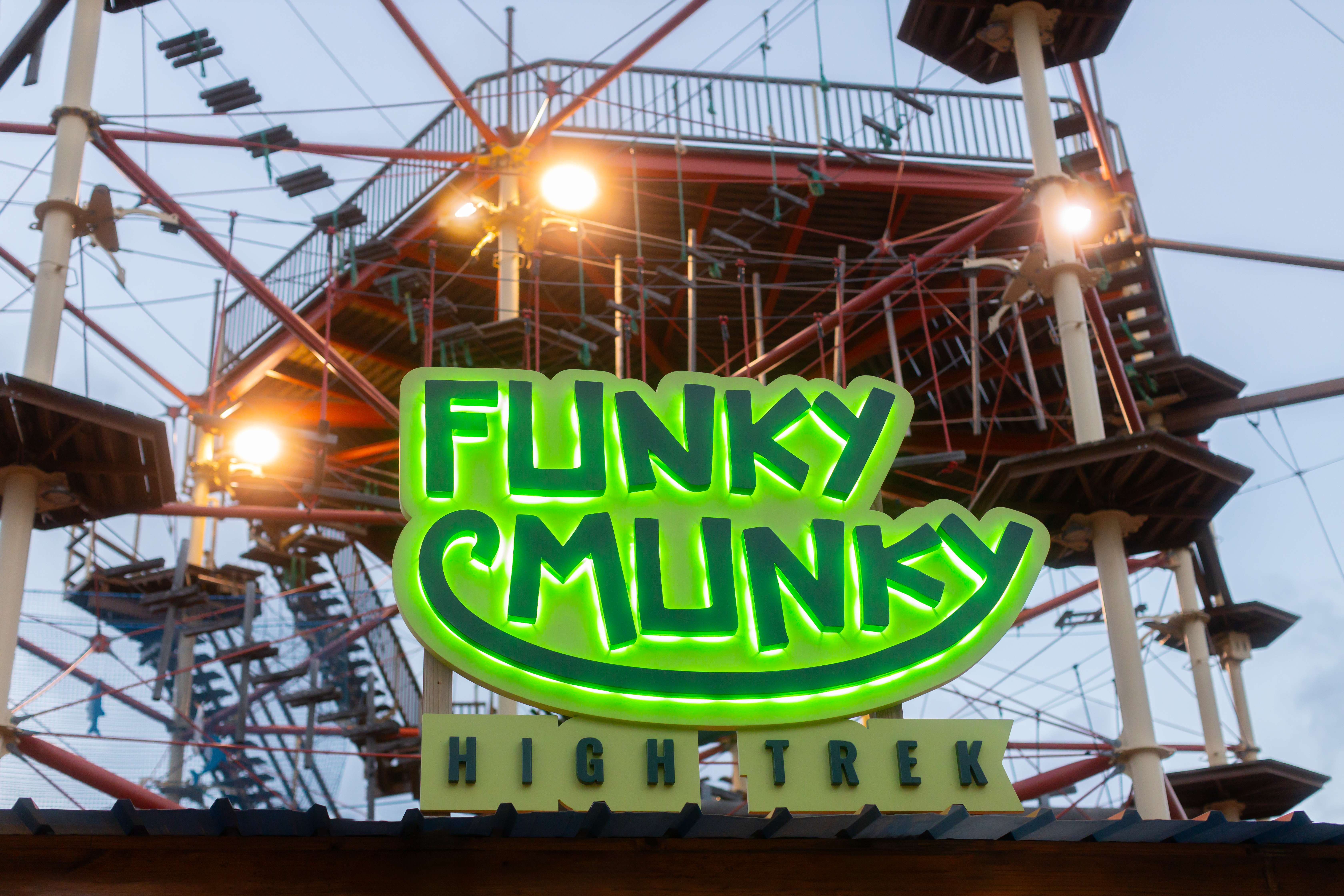 Funky Munky High Trek neon sign with an adventure high ropes course.