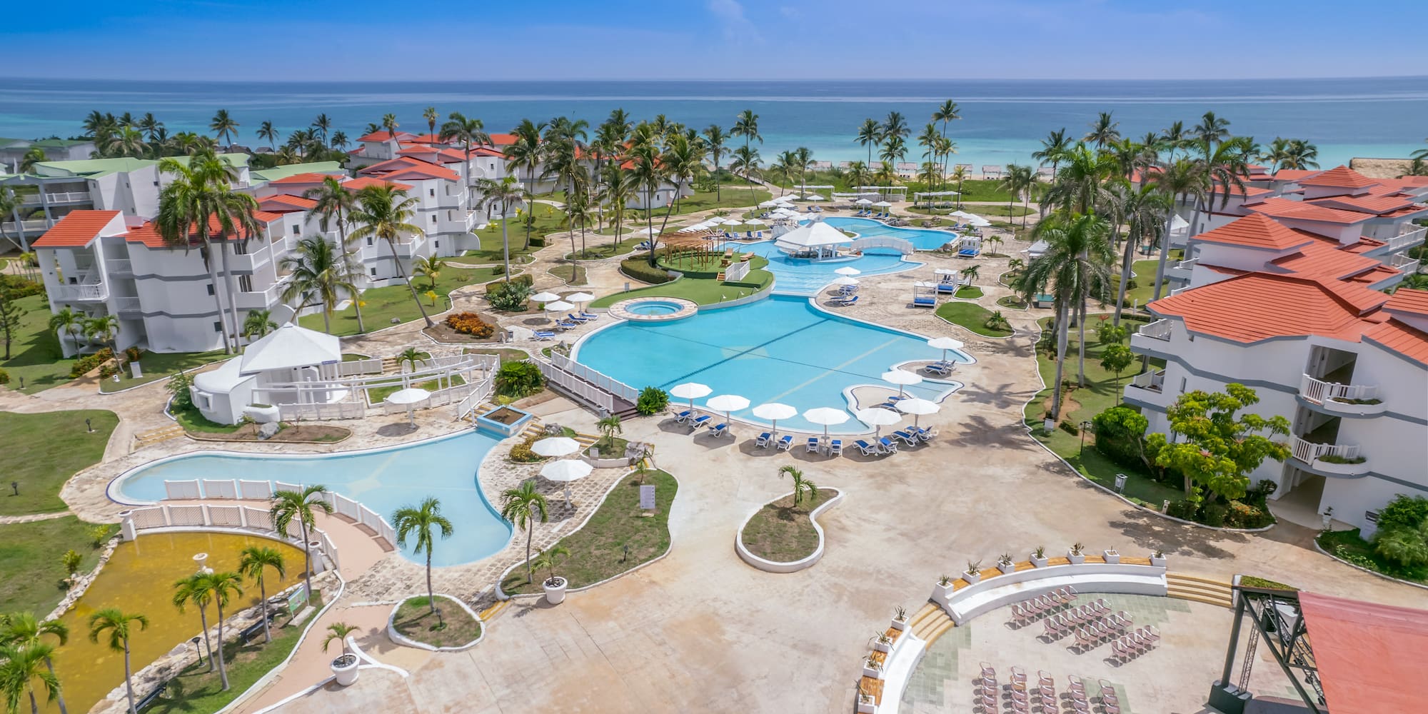 a swimming pool and palm trees next to a resort