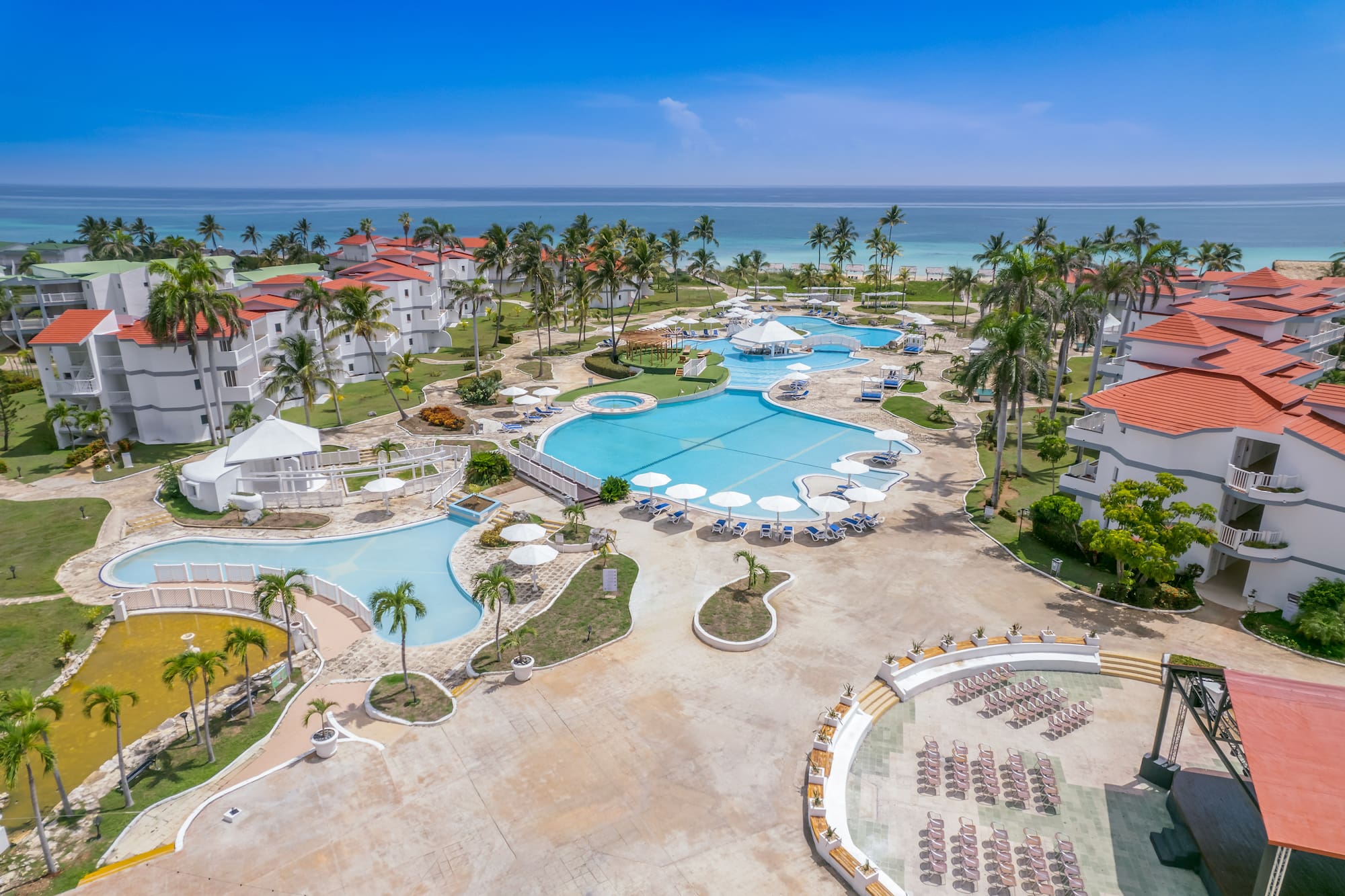 a swimming pool and palm trees next to a resort