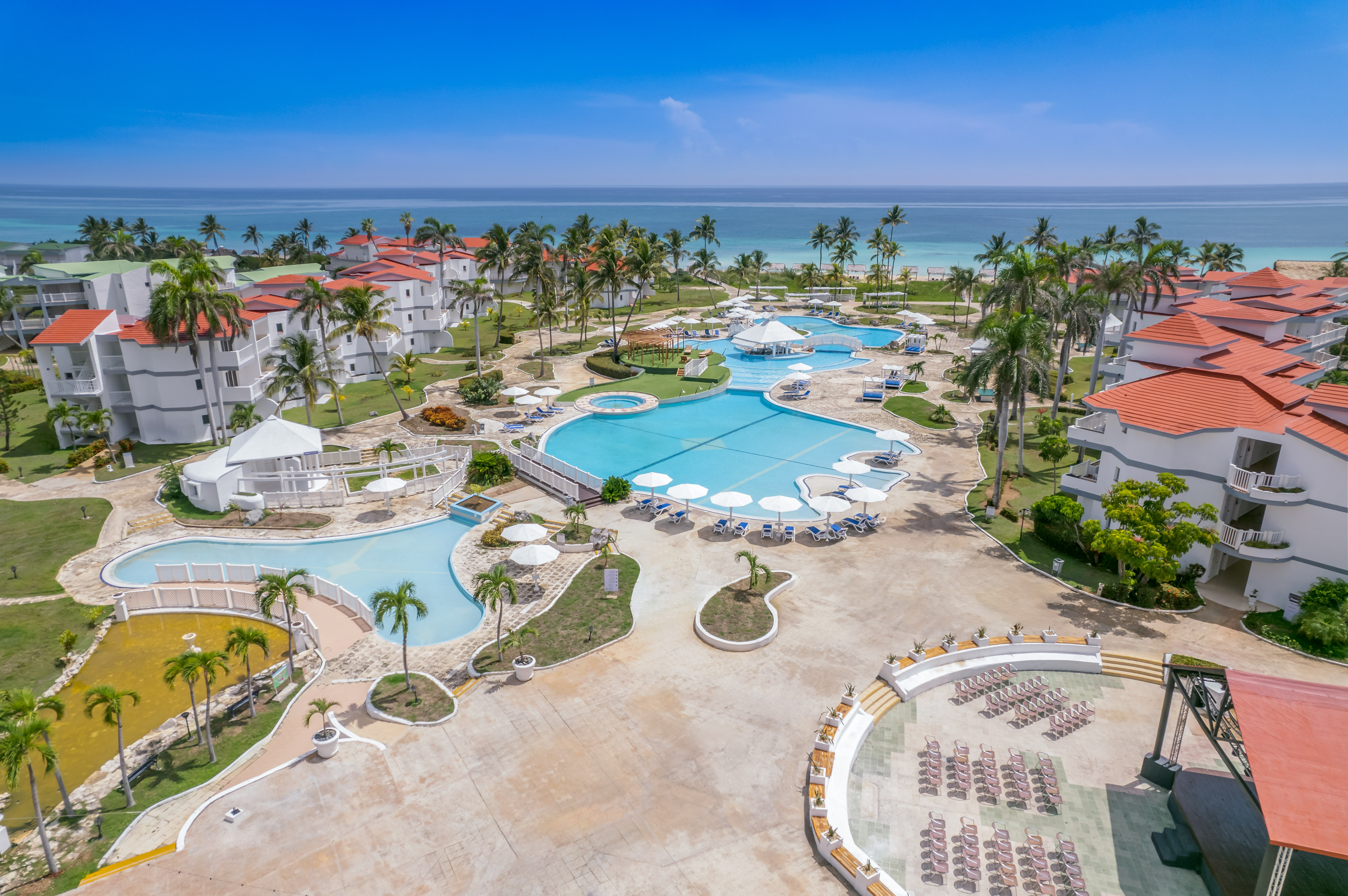 a swimming pool and palm trees next to a resort