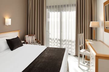 a bedroom with a bed and chairs