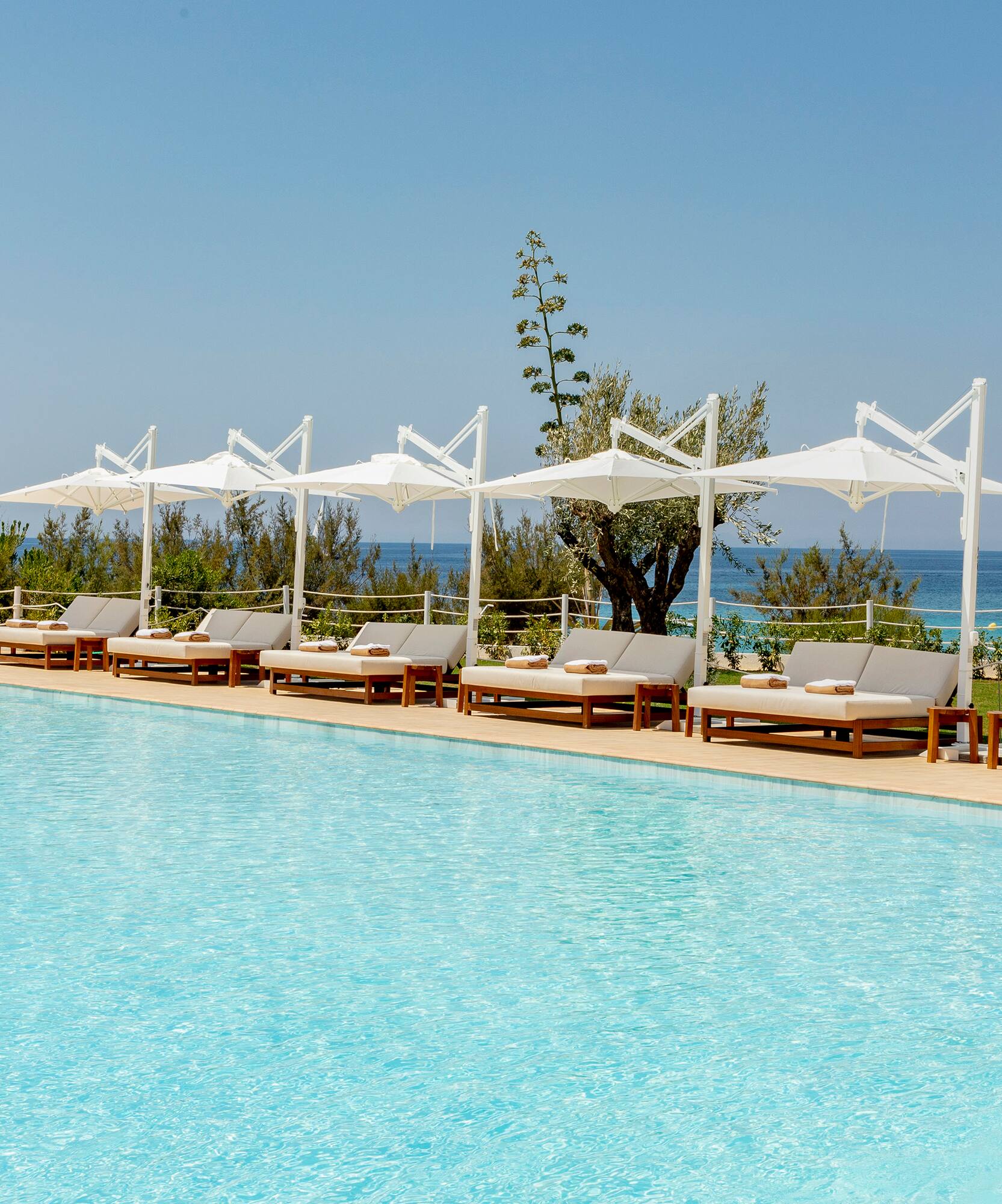 a pool with lounge chairs and umbrellas