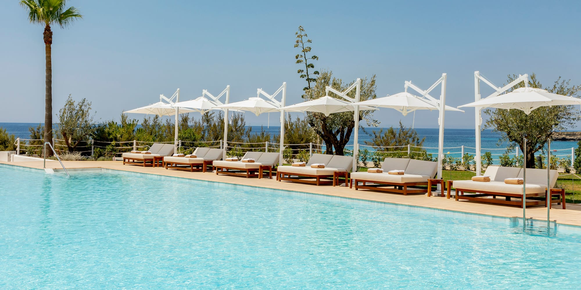 a pool with lounge chairs and umbrellas