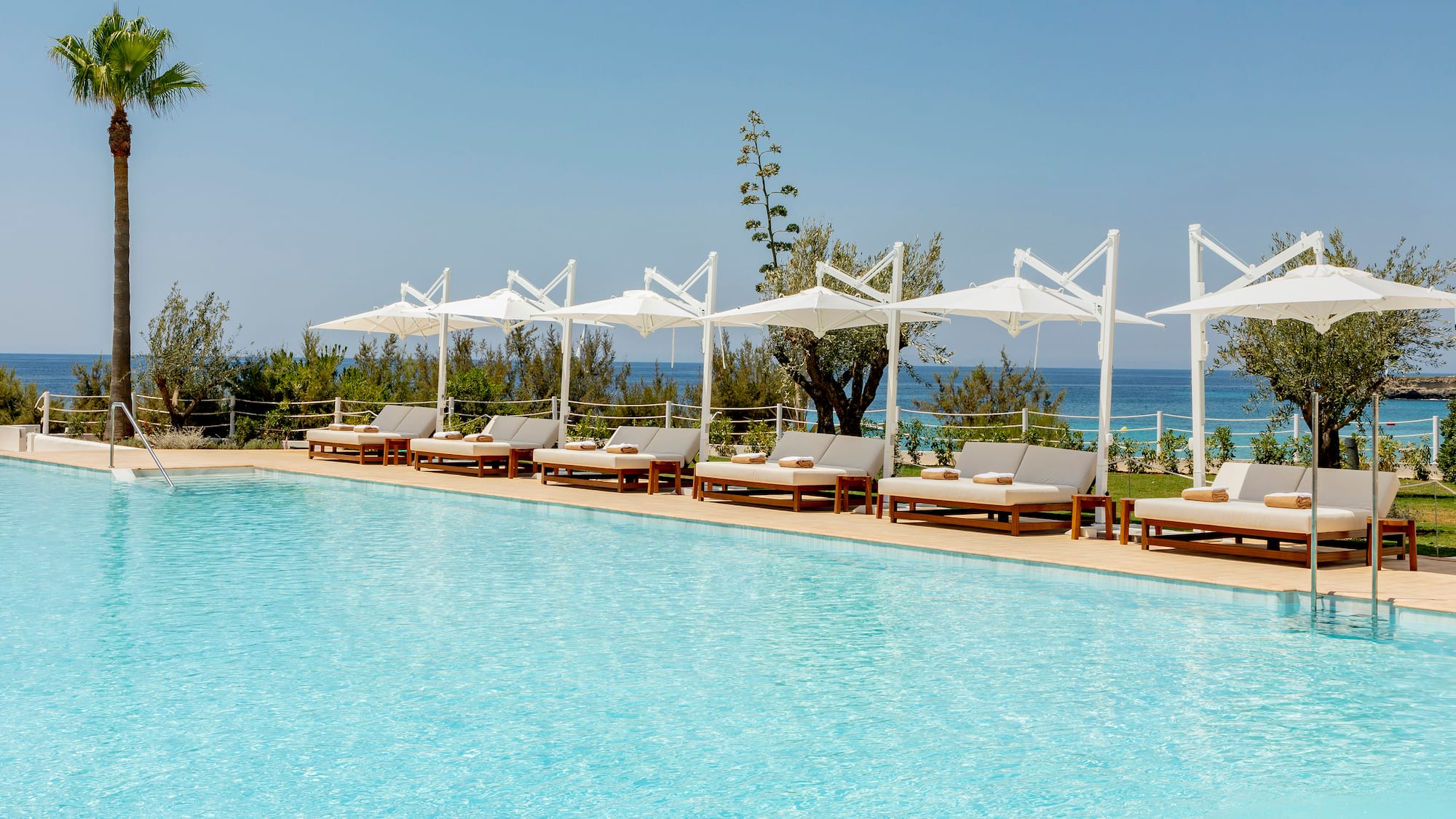 a pool with lounge chairs and umbrellas