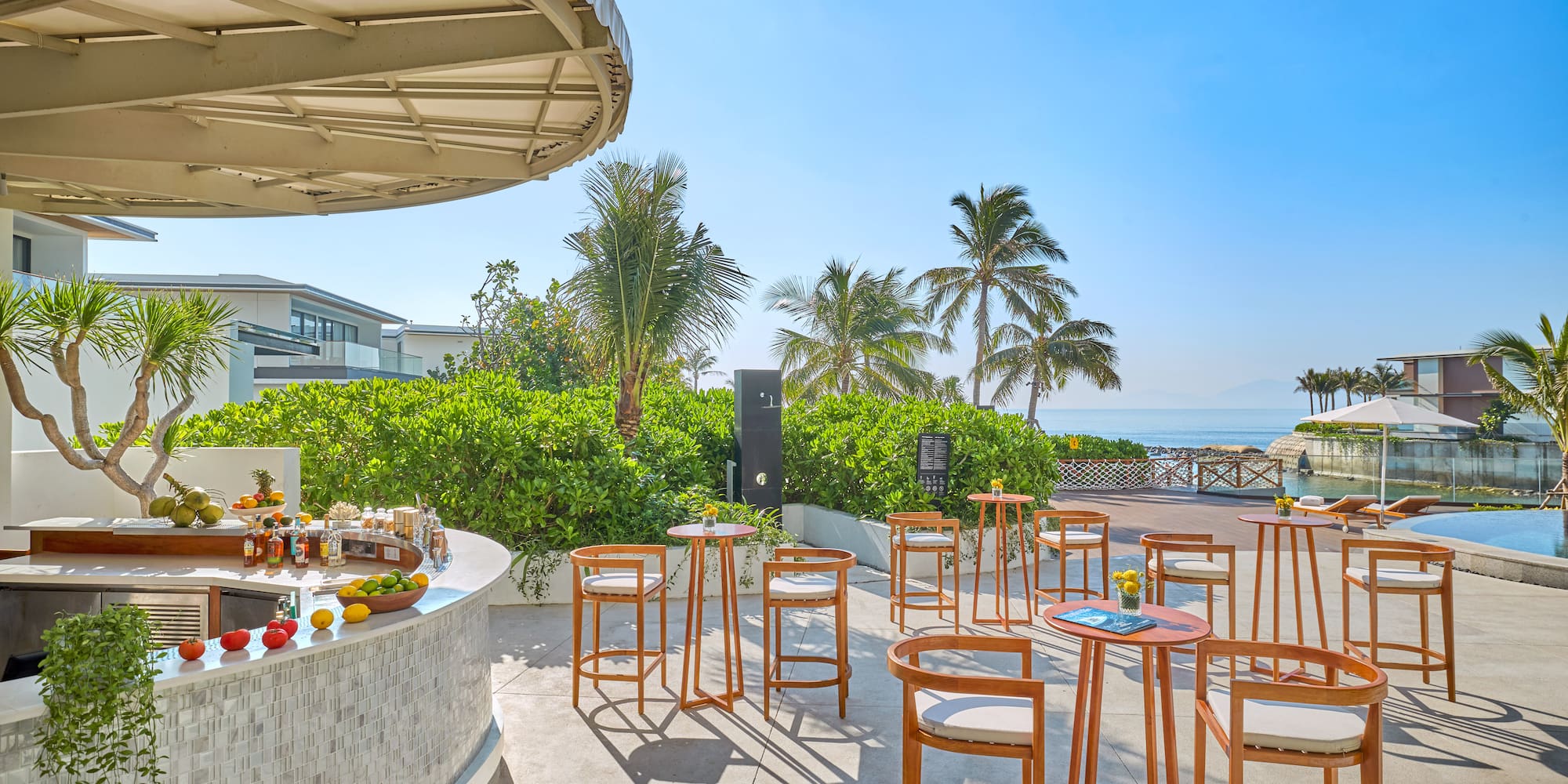 a table and chairs outside with a beach and trees