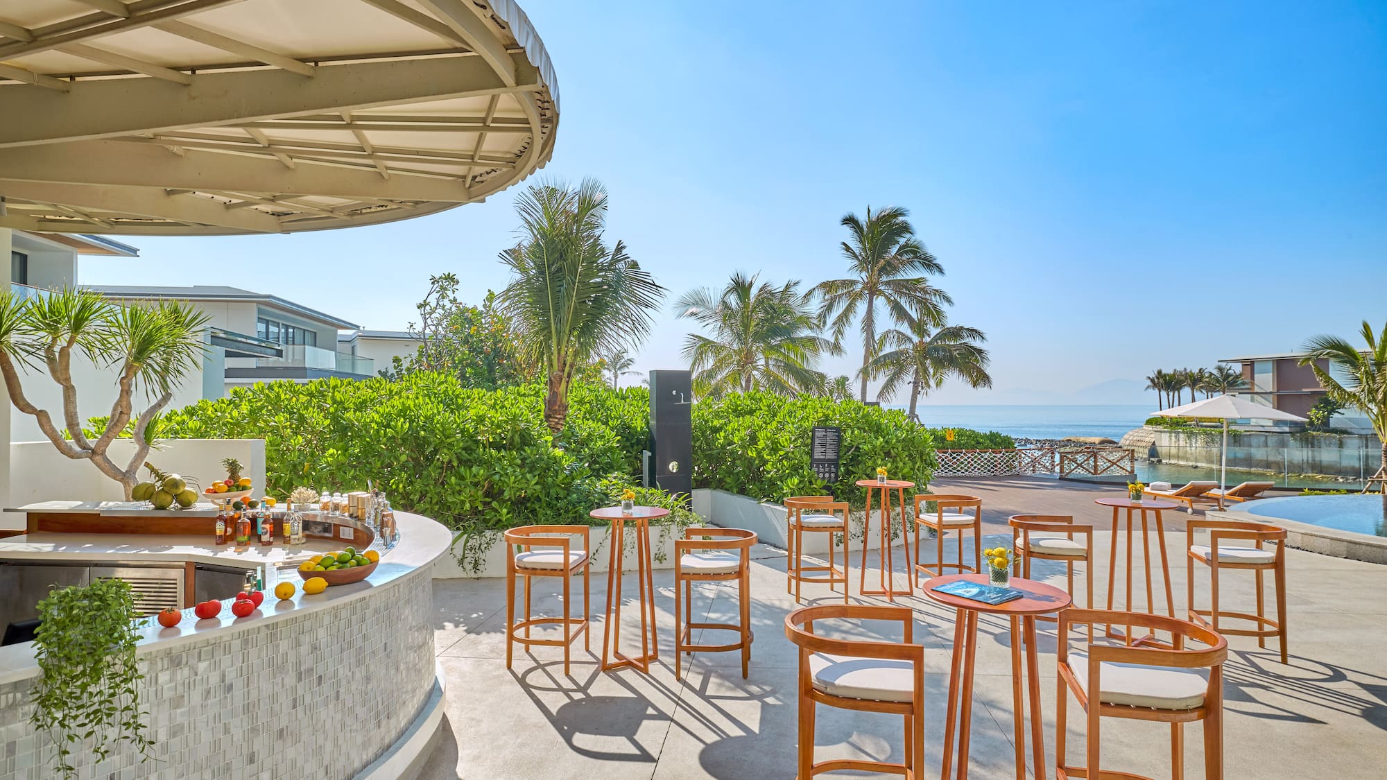 a table and chairs outside with a beach and trees