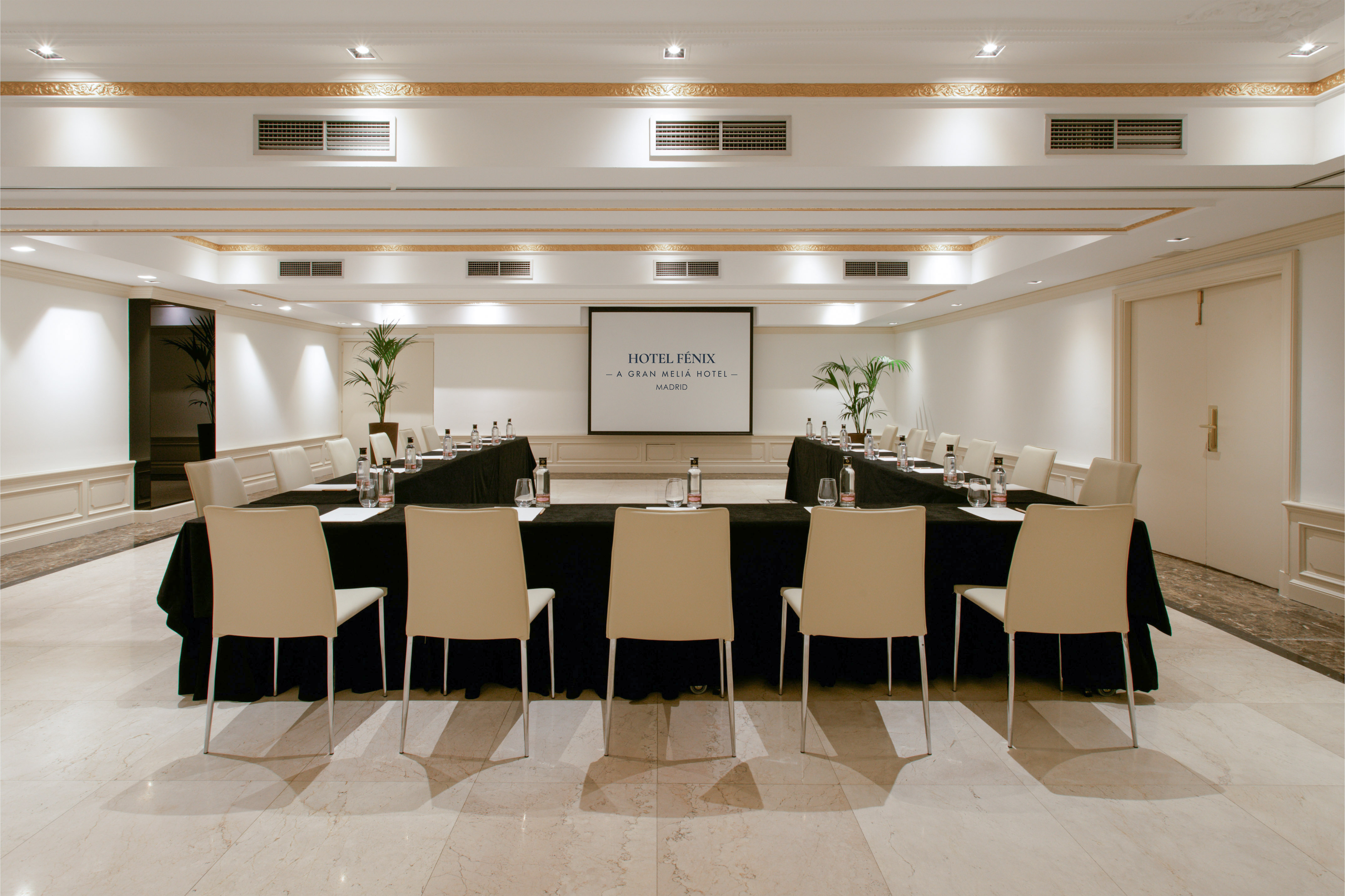Hotel Fénix Madrid conference room with U-shaped tables and presentation screen.