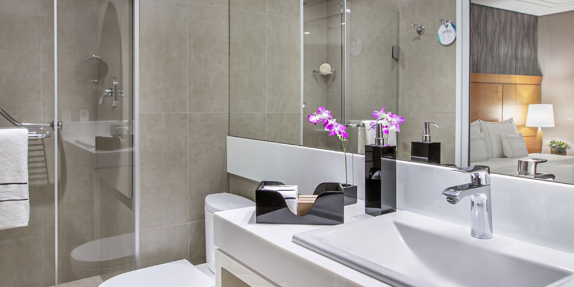 a bathroom with a glass shower door and sink