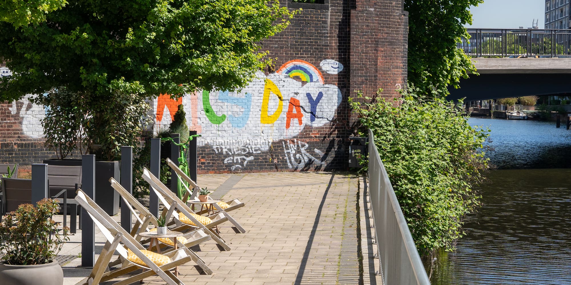 a group of chairs on a sidewalk next to a wall with graffiti