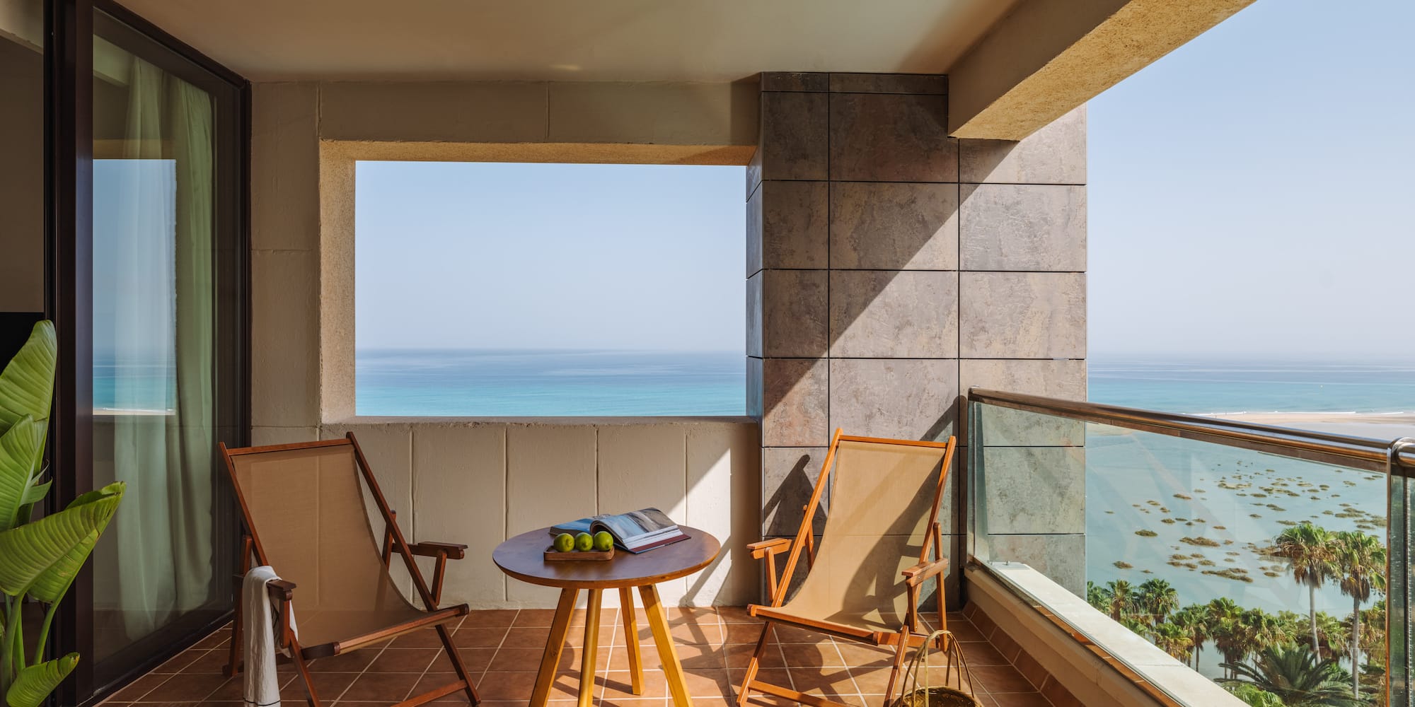 a deck with chairs and a table on a tile floor