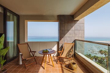 a deck with chairs and a table on a tile floor