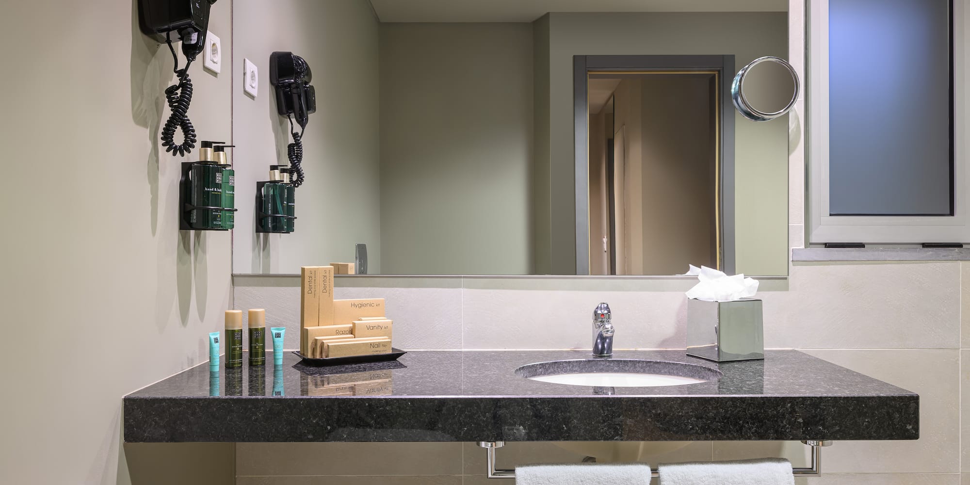 a bathroom with a black countertop and a mirror
