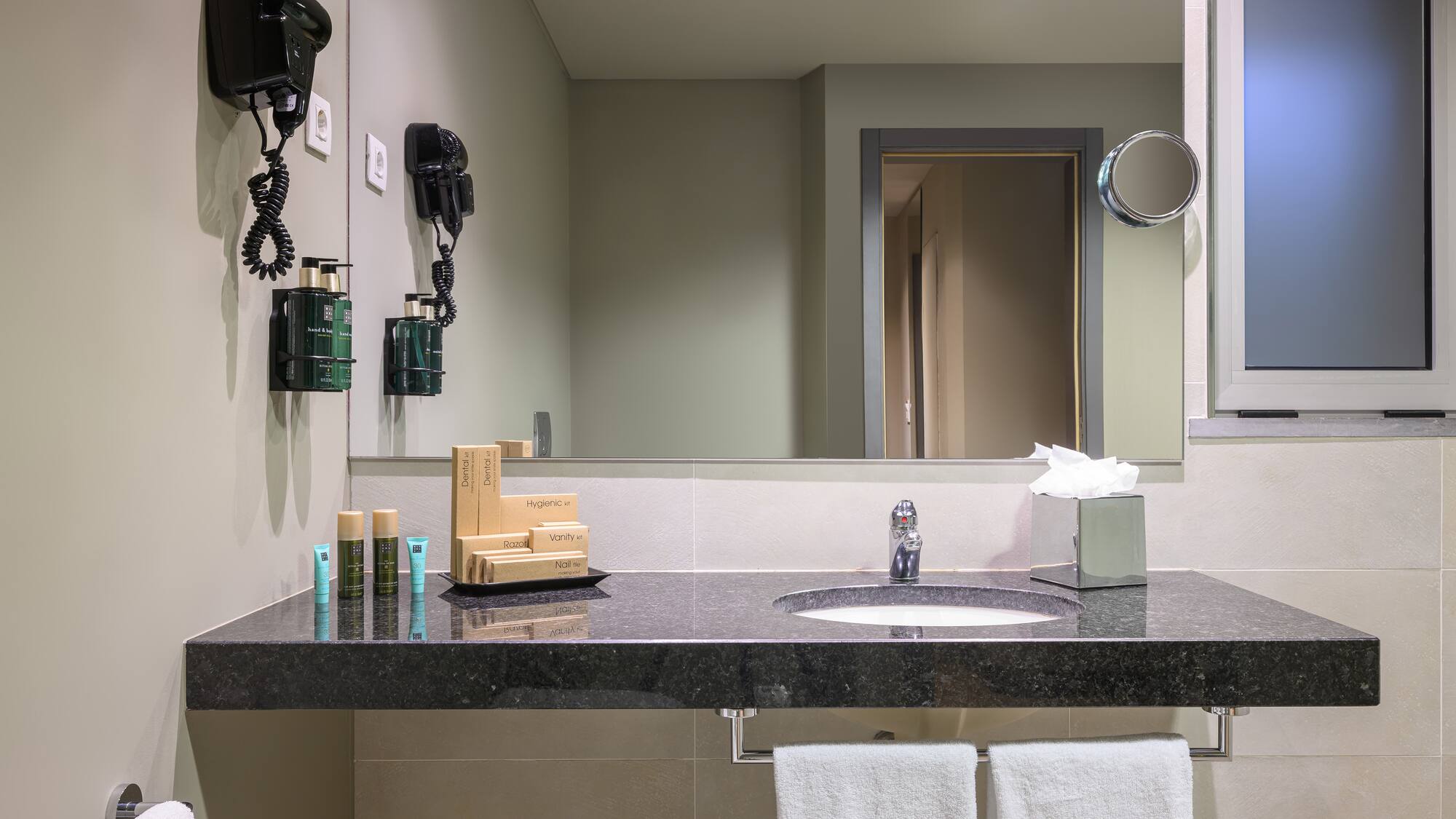 a bathroom with a black countertop and a mirror