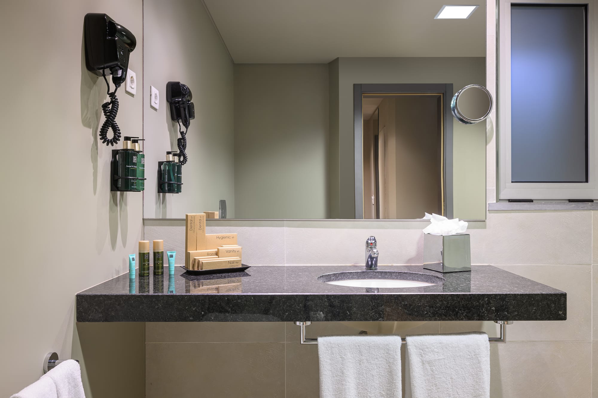 a bathroom with a black countertop and a mirror