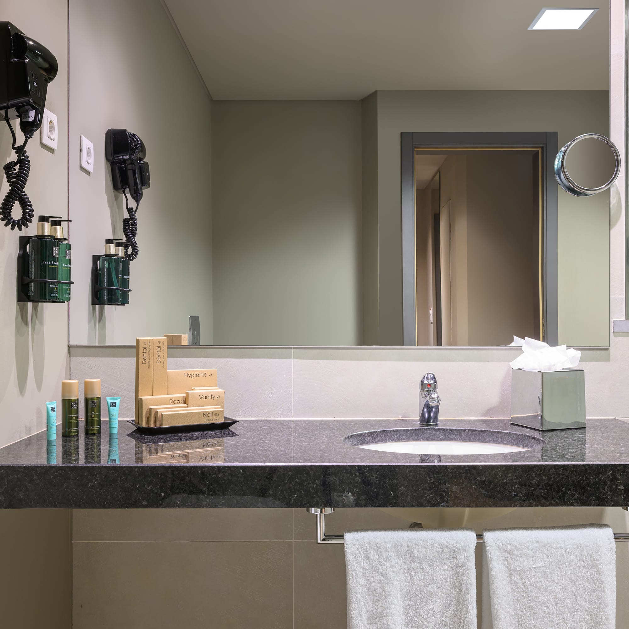 a bathroom with a black countertop and a mirror