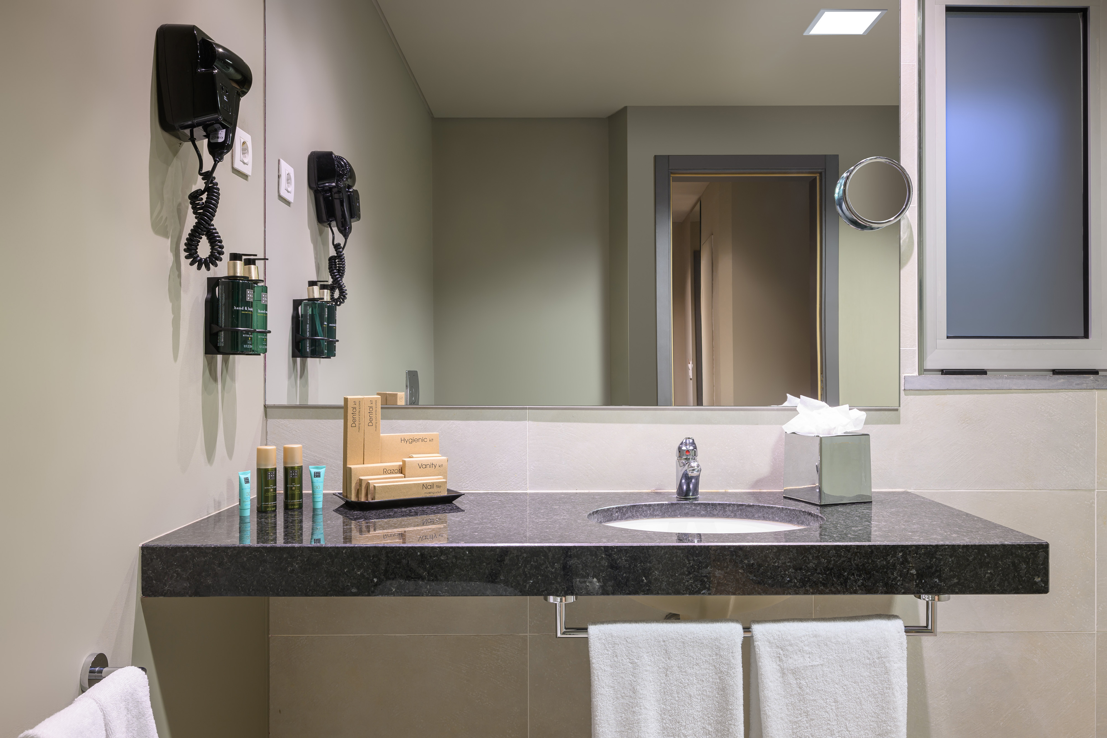 a bathroom with a black countertop and a mirror