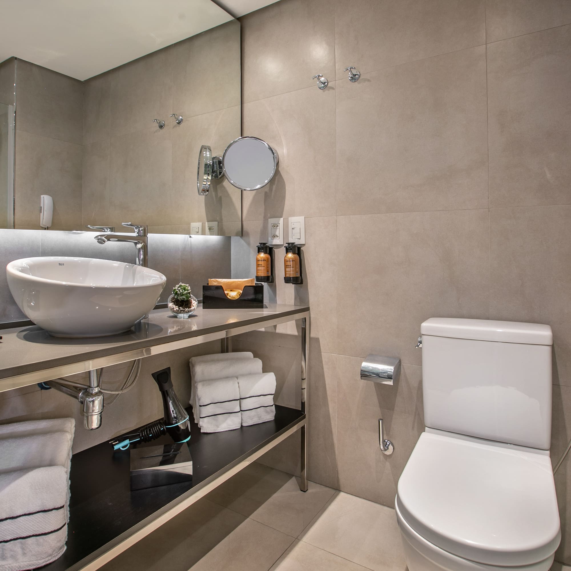 Banheiro de hotel moderno com pia de cuba e vaso sanitário. - Grand Premium - Meliá Ibirapuera, São Paulo