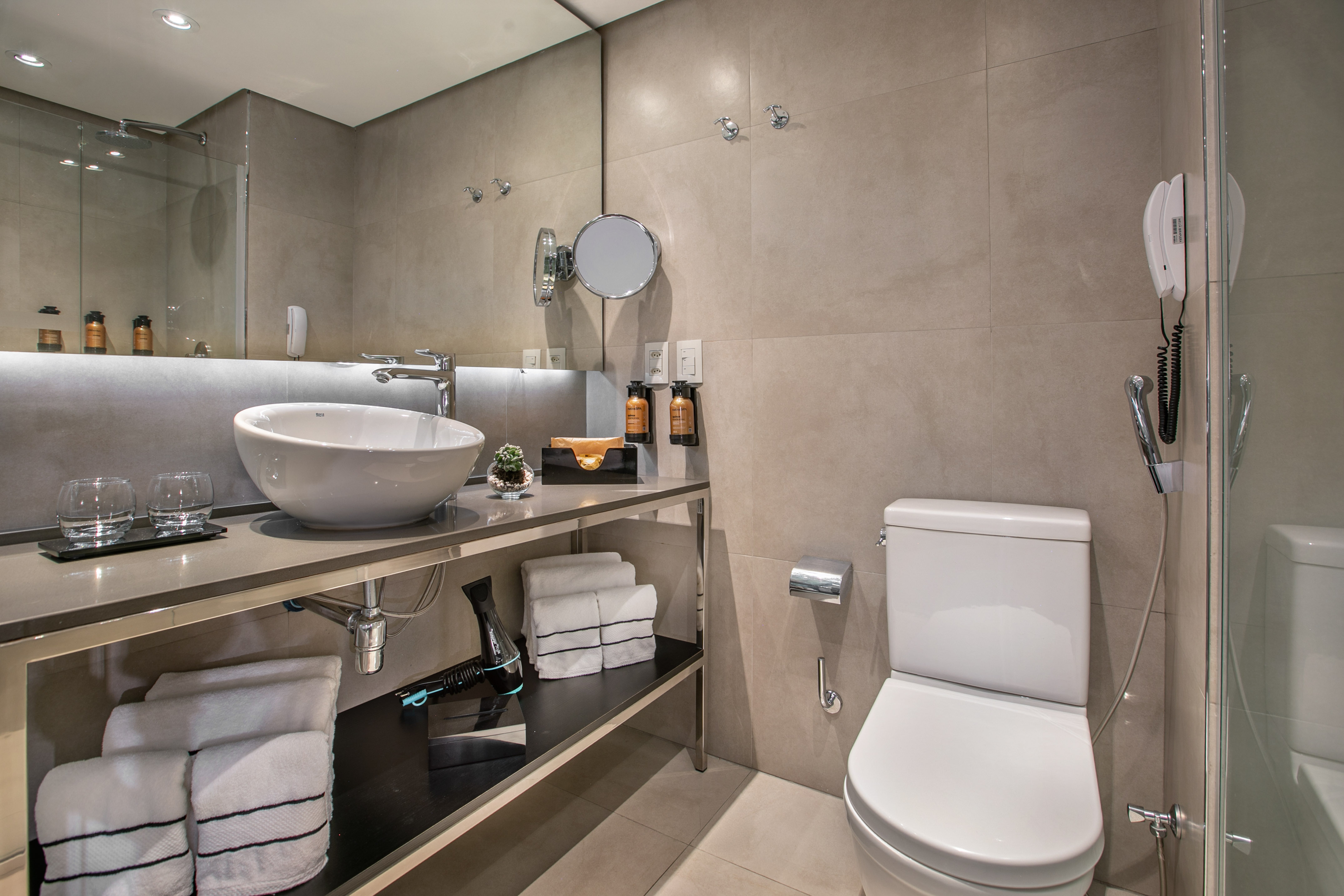 Banheiro de hotel moderno com pia de cuba e vaso sanitário. - Grand Premium - Meliá Ibirapuera, São Paulo