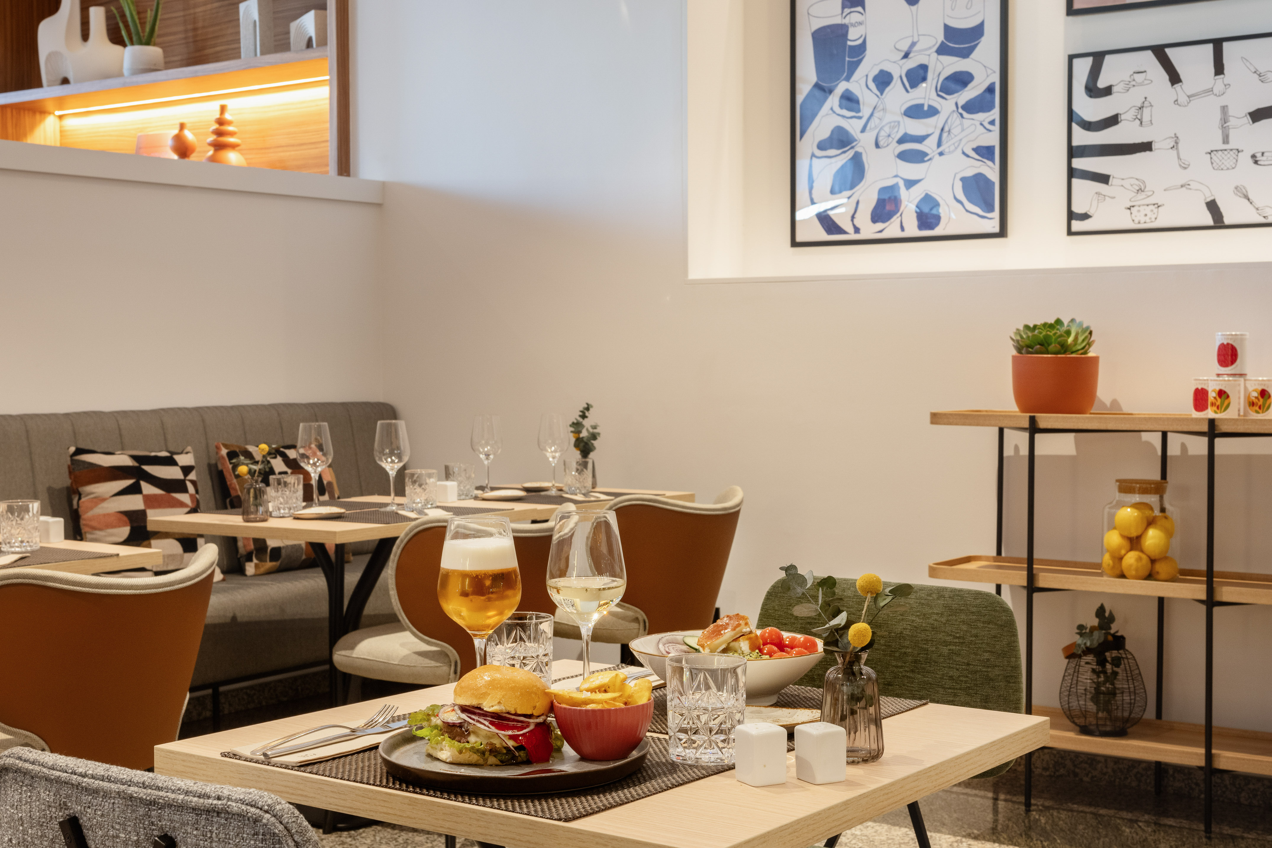 Restaurant dining table with burger, fries, salad, beer, and white wine.