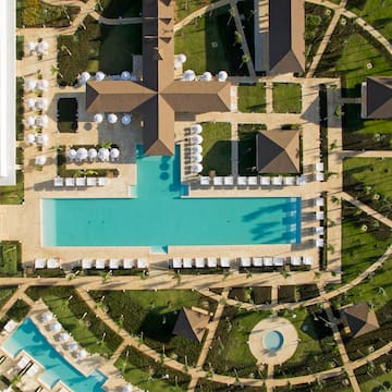 an aerial view of a resort with a pool and lawns