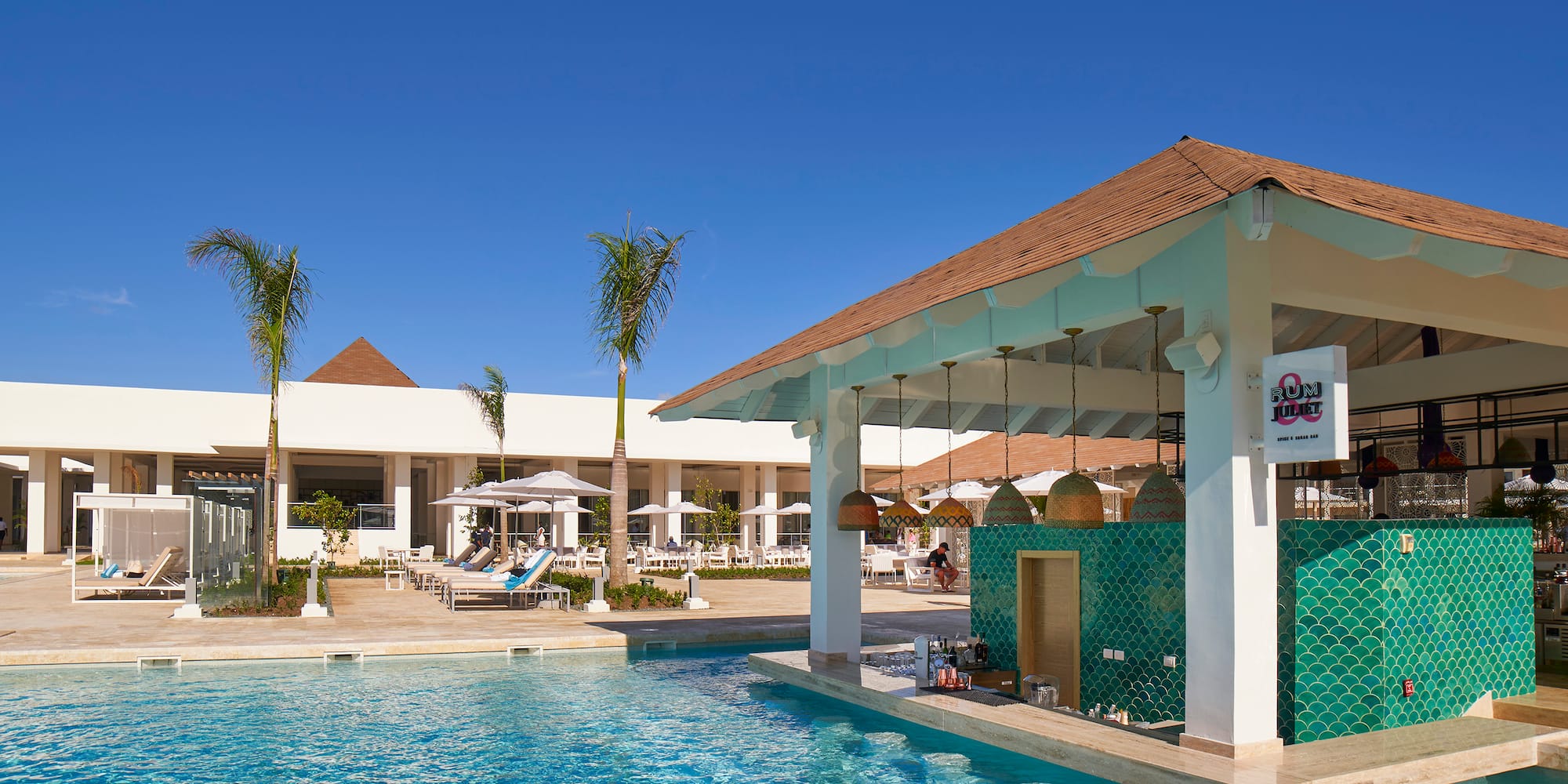 a pool with a bar and chairs in front of it